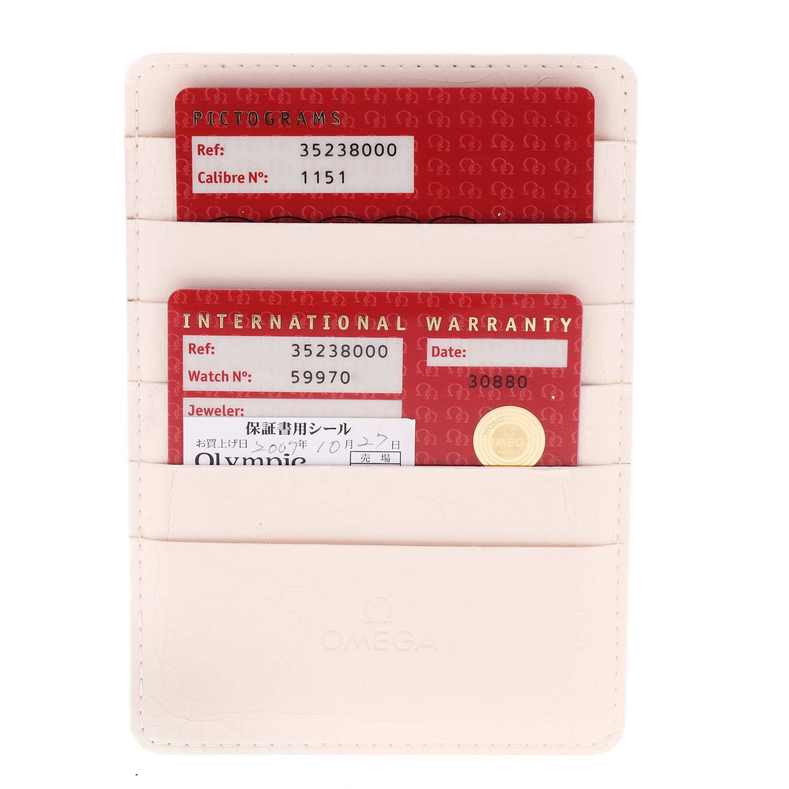 This image shows the pictograms and international warranty cards for an Omega Speedmaster 3523.80.00 Men
s Stainless Steel Blue Dial 3523.80.00 Men
s Stainless Steel Blue Dial watch in a cream-colored cardholder.