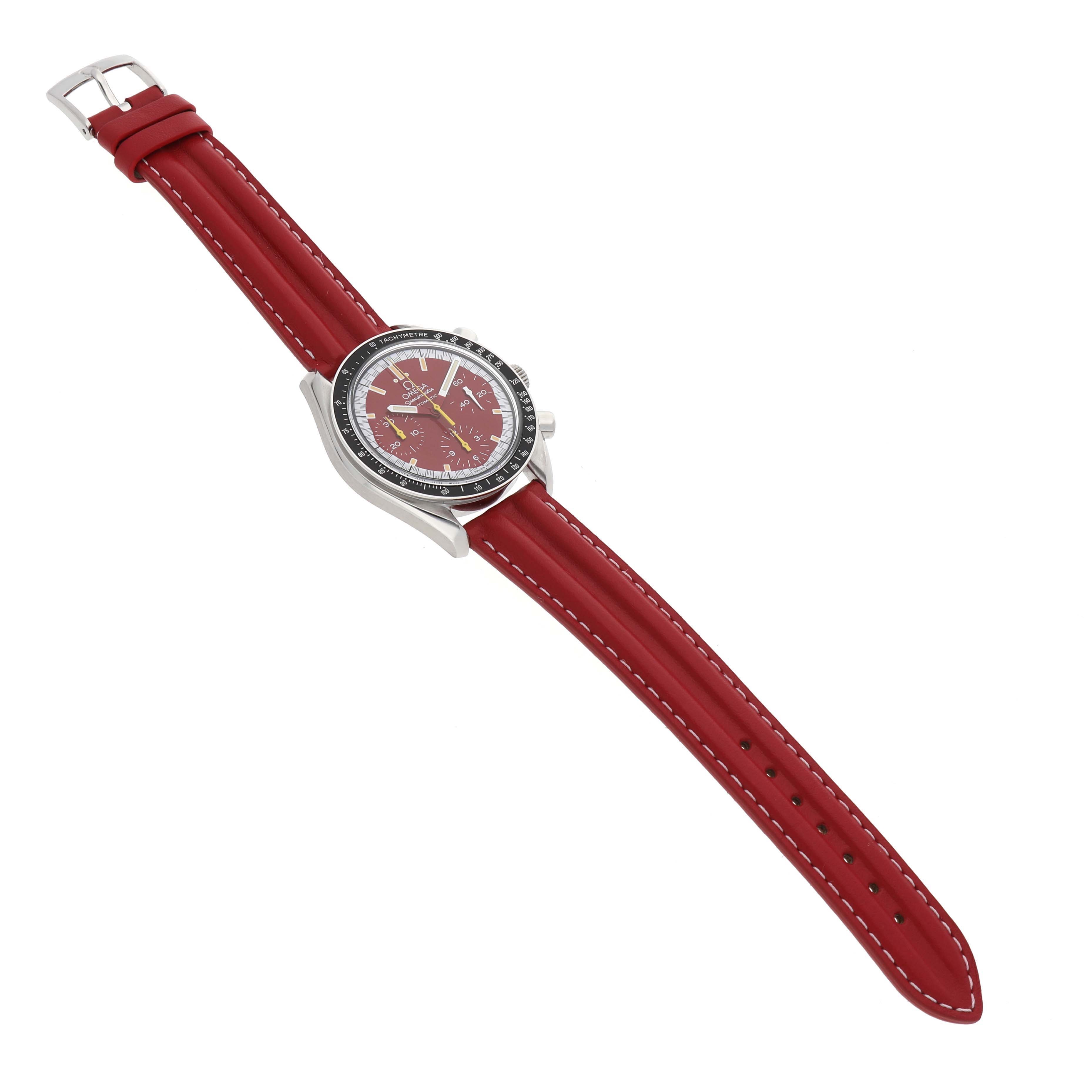 The Omega Speedmaster 3810.61.41 Men's Stainless Steel Red Dial watch is shown at a slight angle, featuring a red strap and visible dial with pushers and crown.