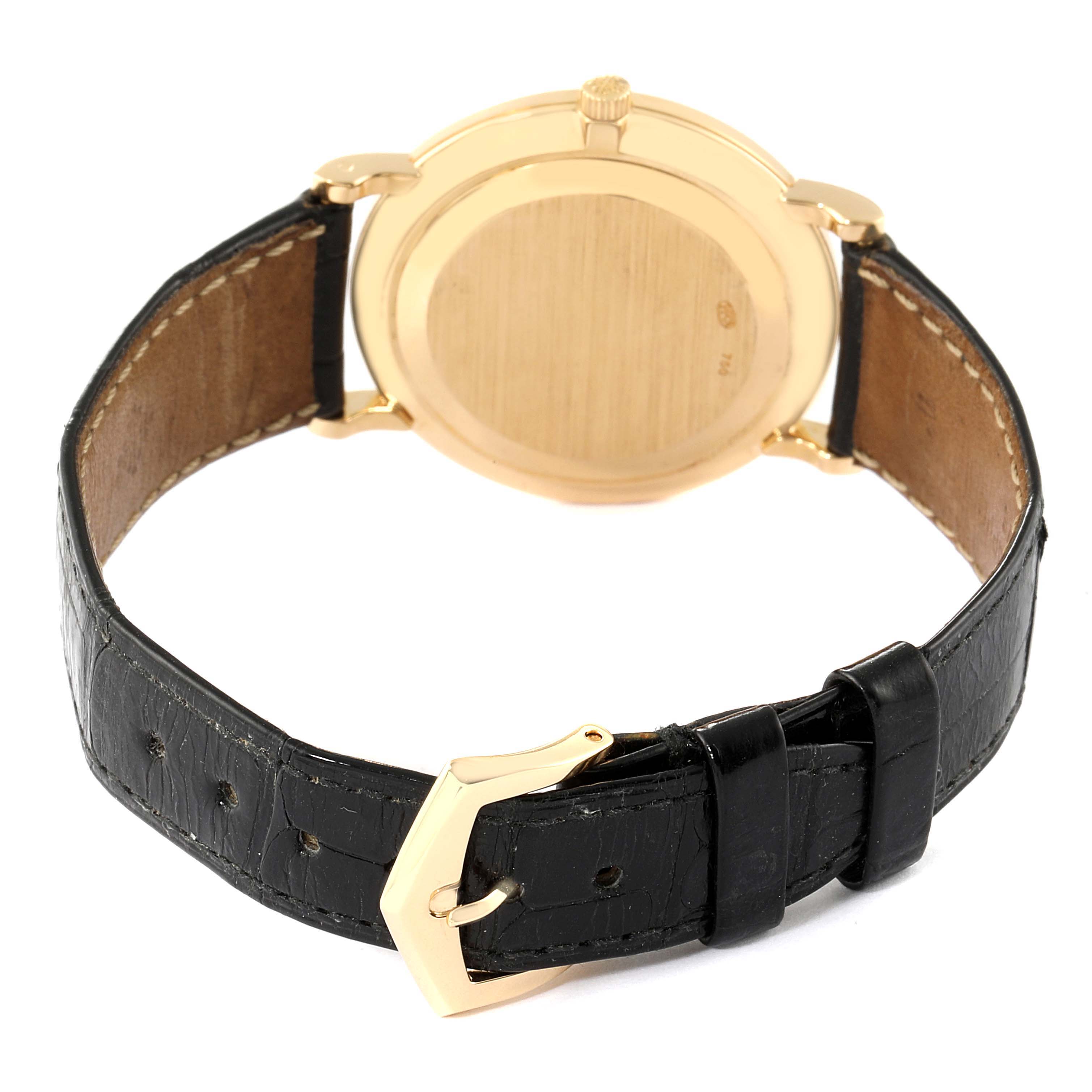 The image shows the back view of a Patek Philippe Calatrava 5022 Men's Yellow Gold White Dial 5022 Men's Yellow Gold White Dial watch, highlighting its caseback, crown, and leather strap with buckle.