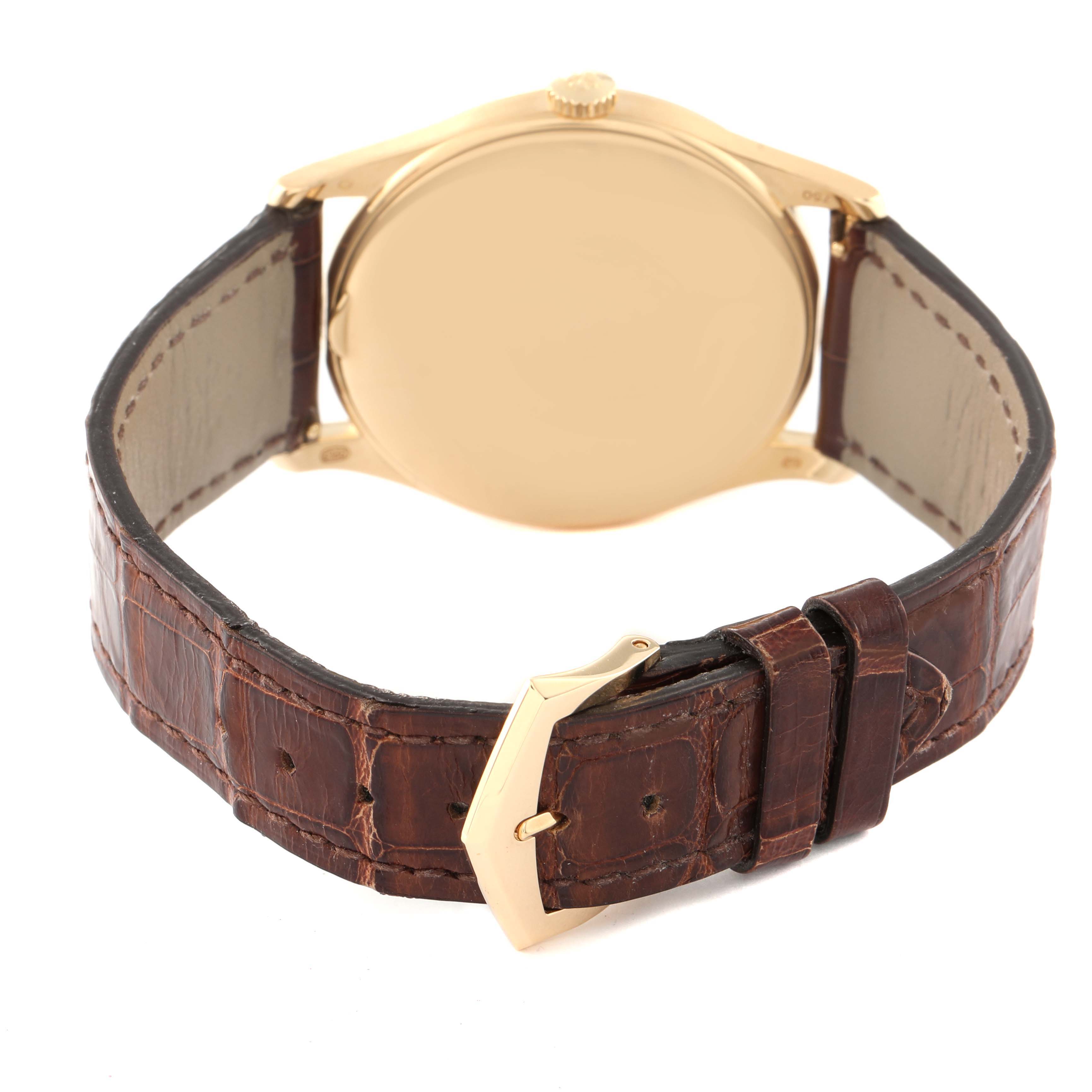 The image shows the back of a Patek Philippe Calatrava 5196J Men's Yellow Gold Silver Dial 5196J Men's Yellow Gold Silver Dial watch and its brown leather strap with a gold buckle.