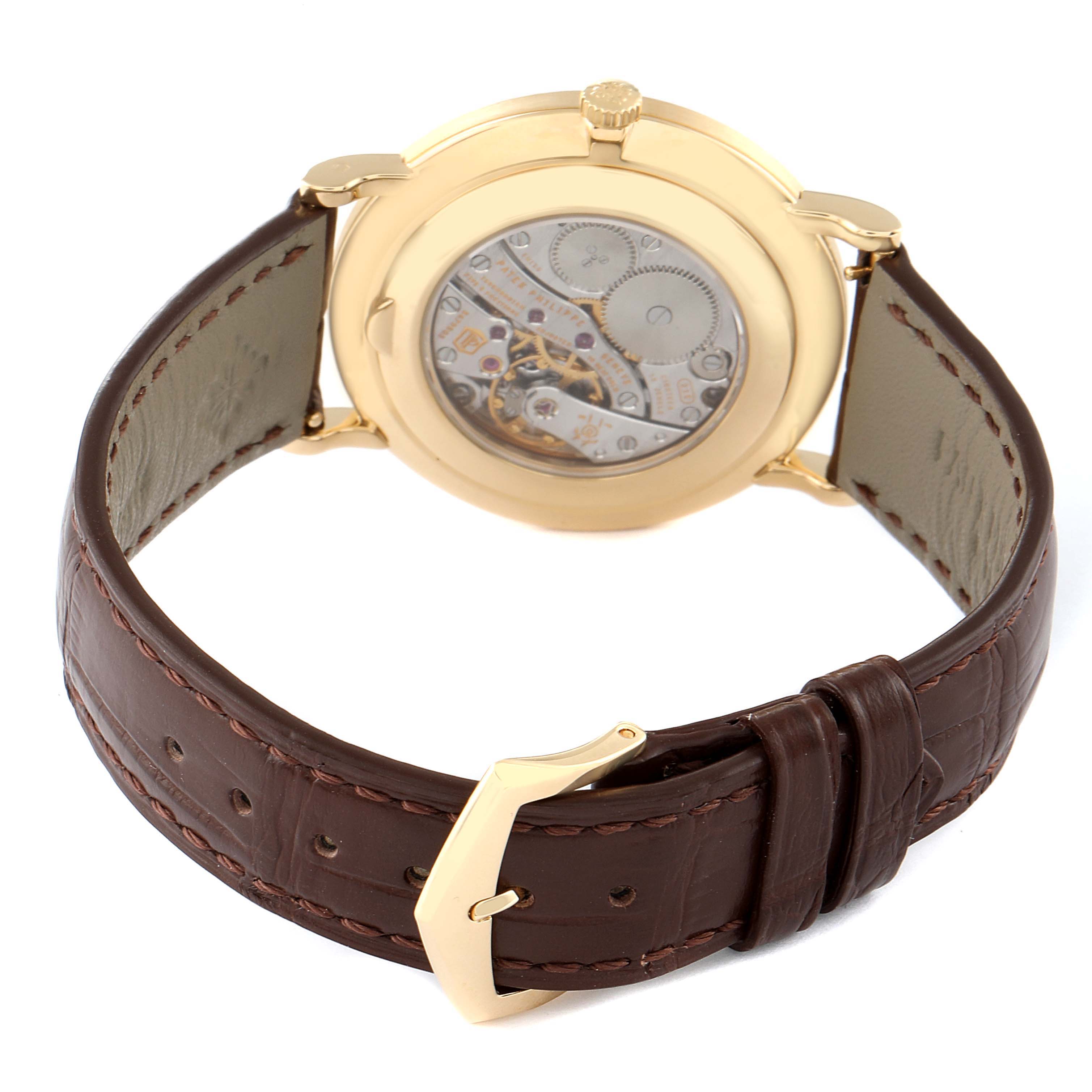 The image shows the back view of the Patek Philippe Calatrava 5119J Men's Yellow Gold White Dial 5119J Men's Yellow Gold White Dial watch, highlighting the movement and brown leather strap.