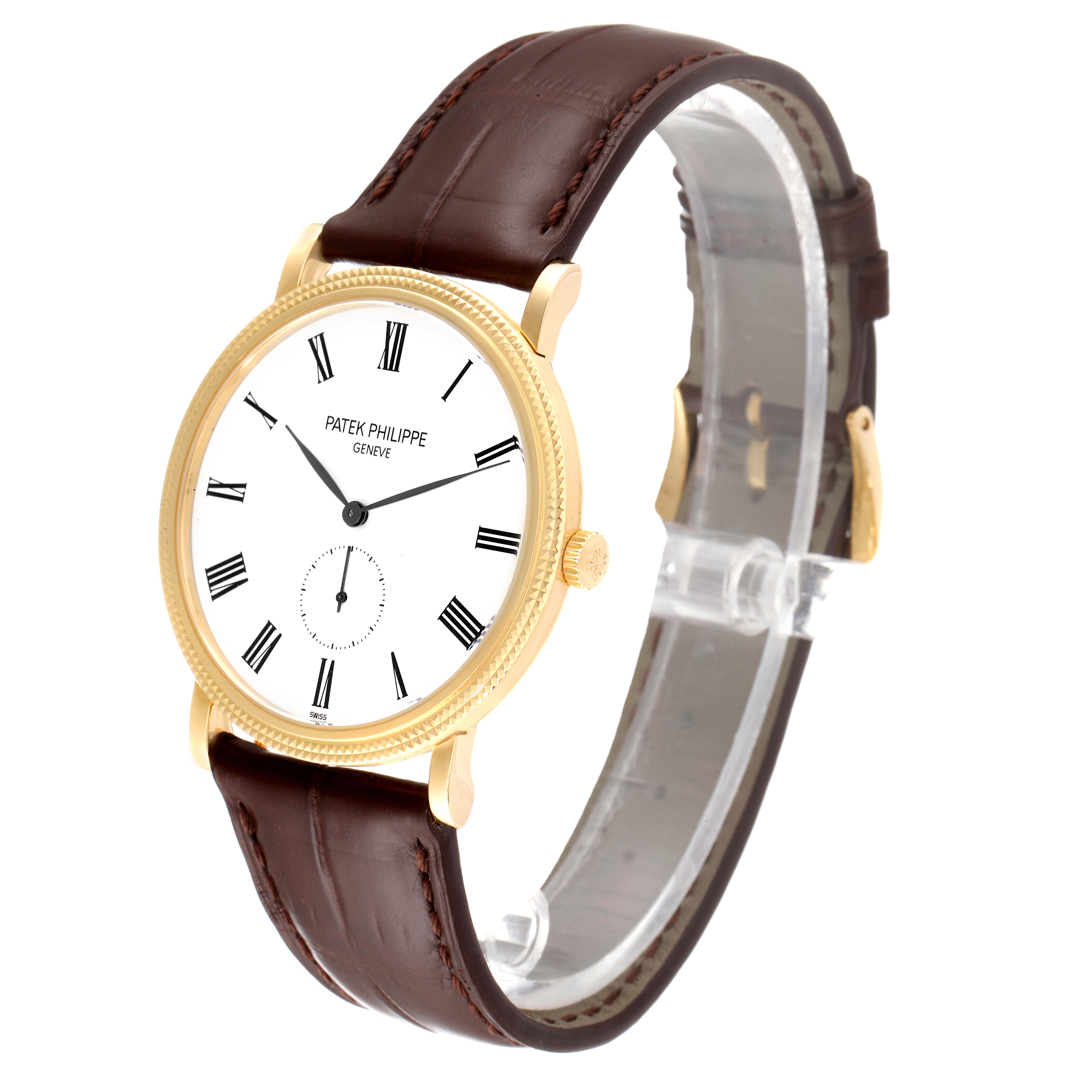 The Patek Philippe Calatrava 5119J Men's Yellow Gold White Dial 5119J Men's Yellow Gold White Dial watch is shown from an angled side view, highlighting the white dial, gold case, crown, and brown leather strap.