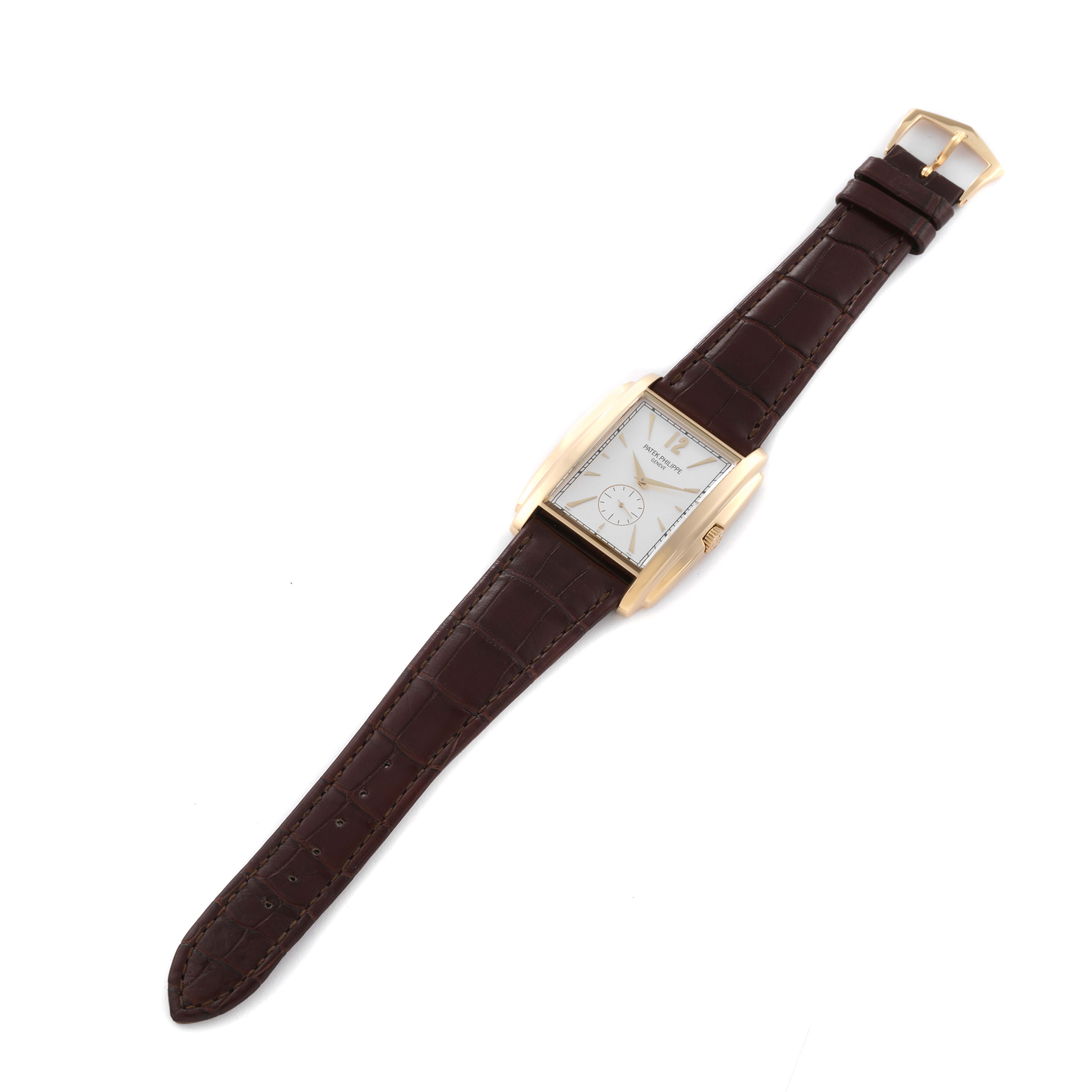 The image shows a top view of a Patek Philippe Gondolo 5124J Men's Yellow Gold Silver Dial 5124J Men's Yellow Gold Silver Dial watch with a brown leather strap and a rectangular gold case.