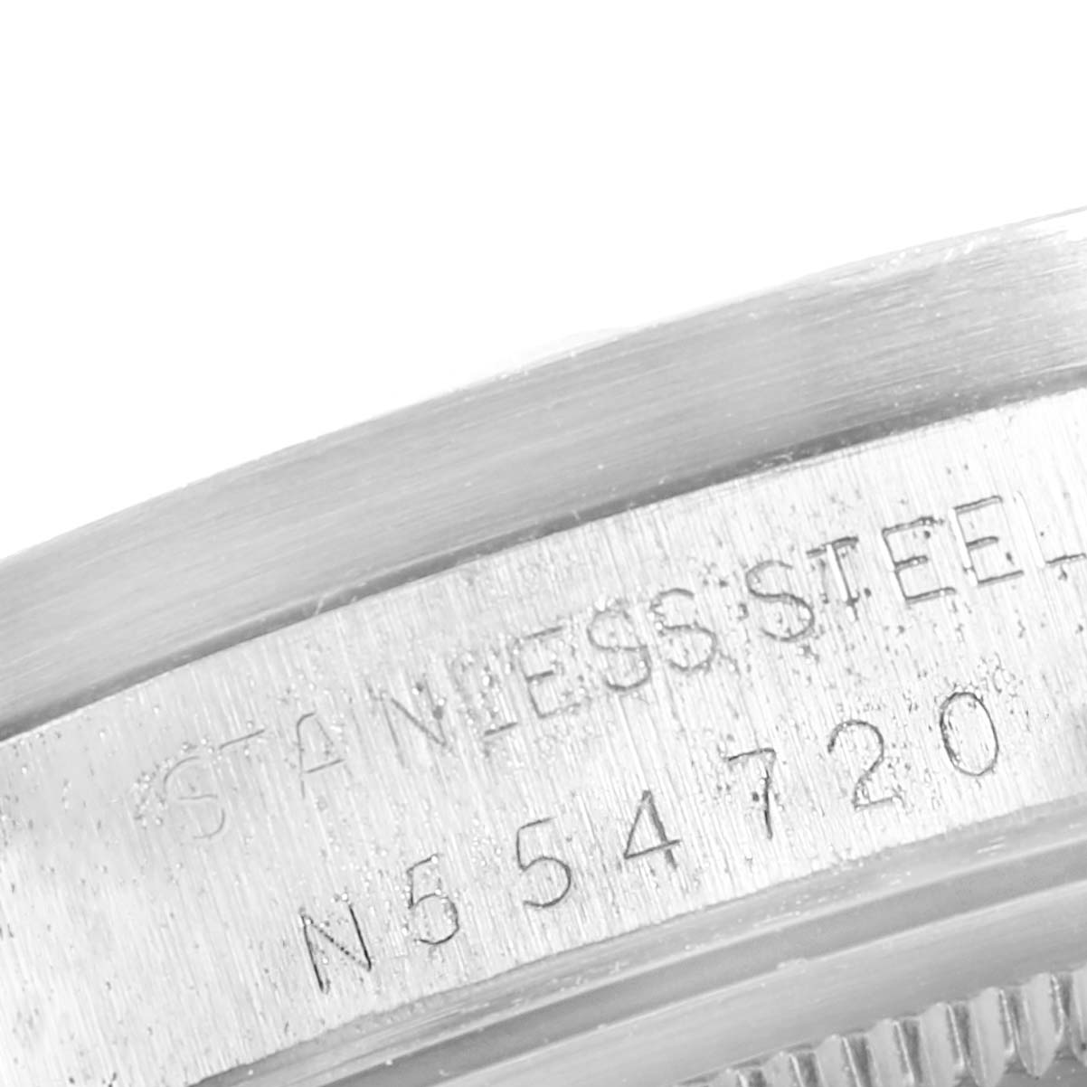 This image shows a close-up of the side of the Rolex Air-King 14010 Men's Stainless Steel Blue Dial 14010 Men's Stainless Steel Blue Dial watch, focusing on the serial number and "STAINLESS STEEL" engraving.