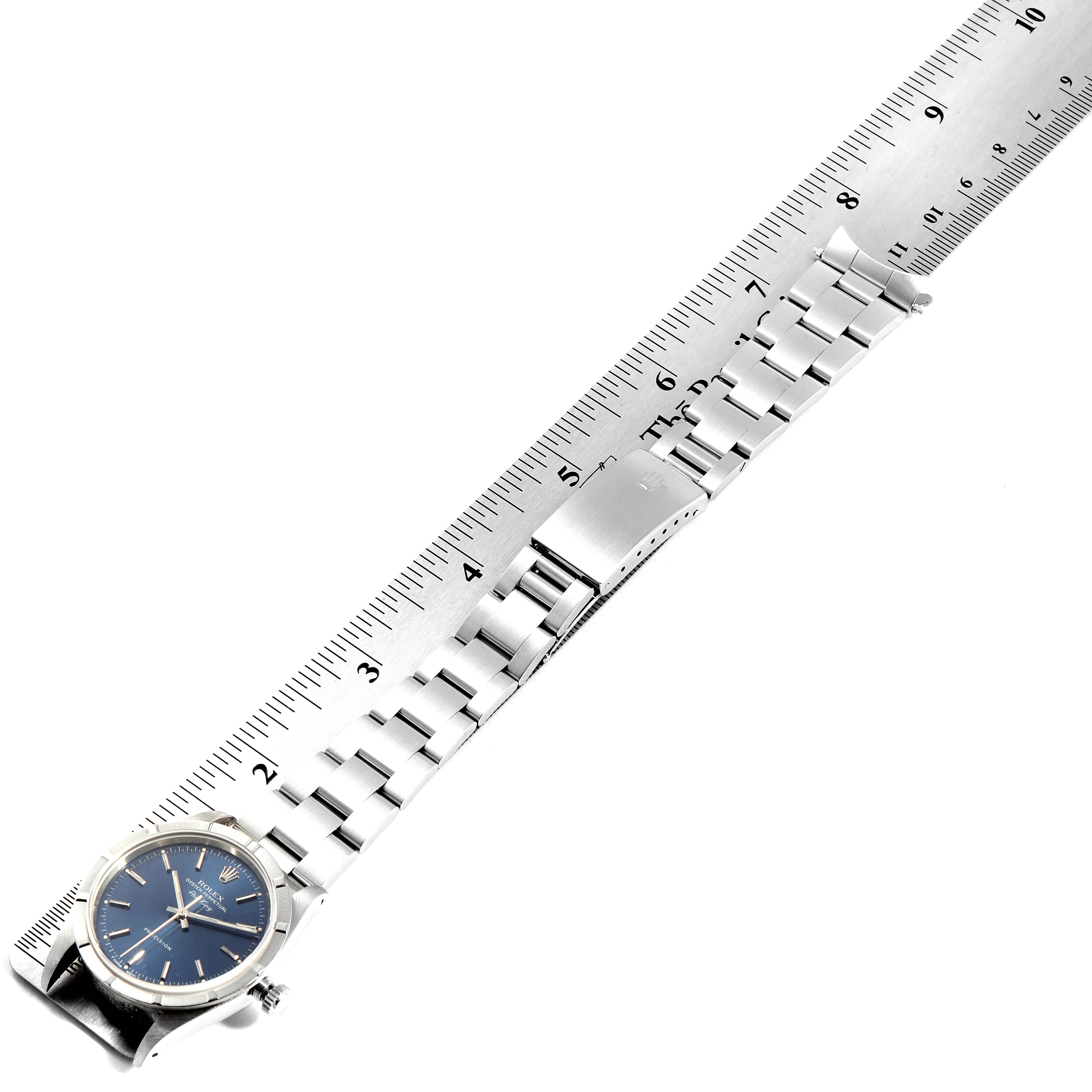 The image shows a Rolex Air-King 14010 Men's Stainless Steel Blue Dial 14010 Men's Stainless Steel Blue Dial watch laid flat next to a ruler, highlighting the watch face and stainless steel bracelet.