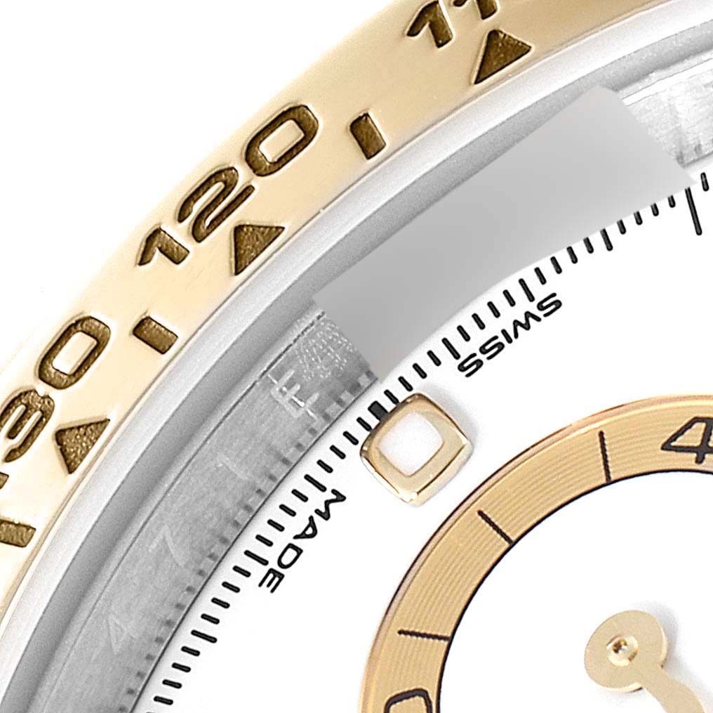 The image shows a close-up of the bezel and part of the dial of a Rolex Daytona 116503 Men's Steel and Gold (two tone) White Dial 116503 Men's Steel and Gold (two tone) White Dial watch.