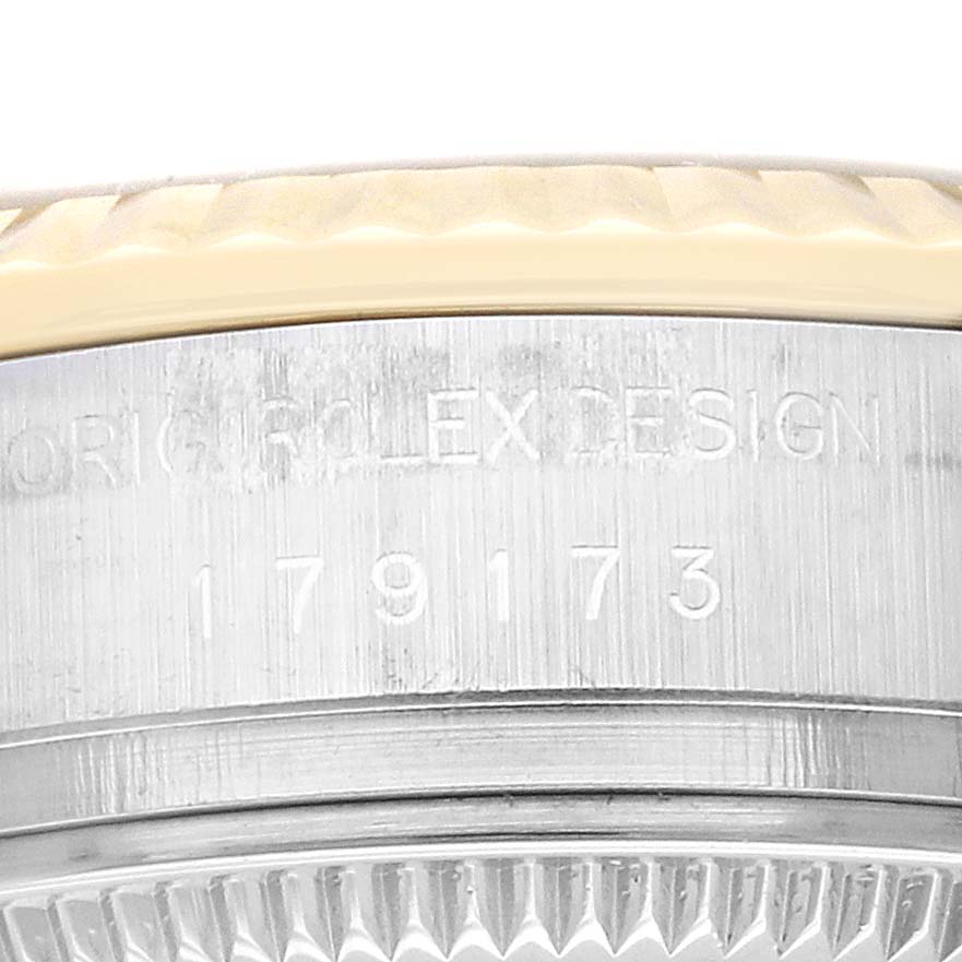 The image shows a close-up of the side of a Rolex Datejust 179173 Women's Steel and Gold (two tone) Champagne Dial 179173 Women's Steel and Gold (two tone) Champagne Dial model, displaying its bezel and engraved serial number.