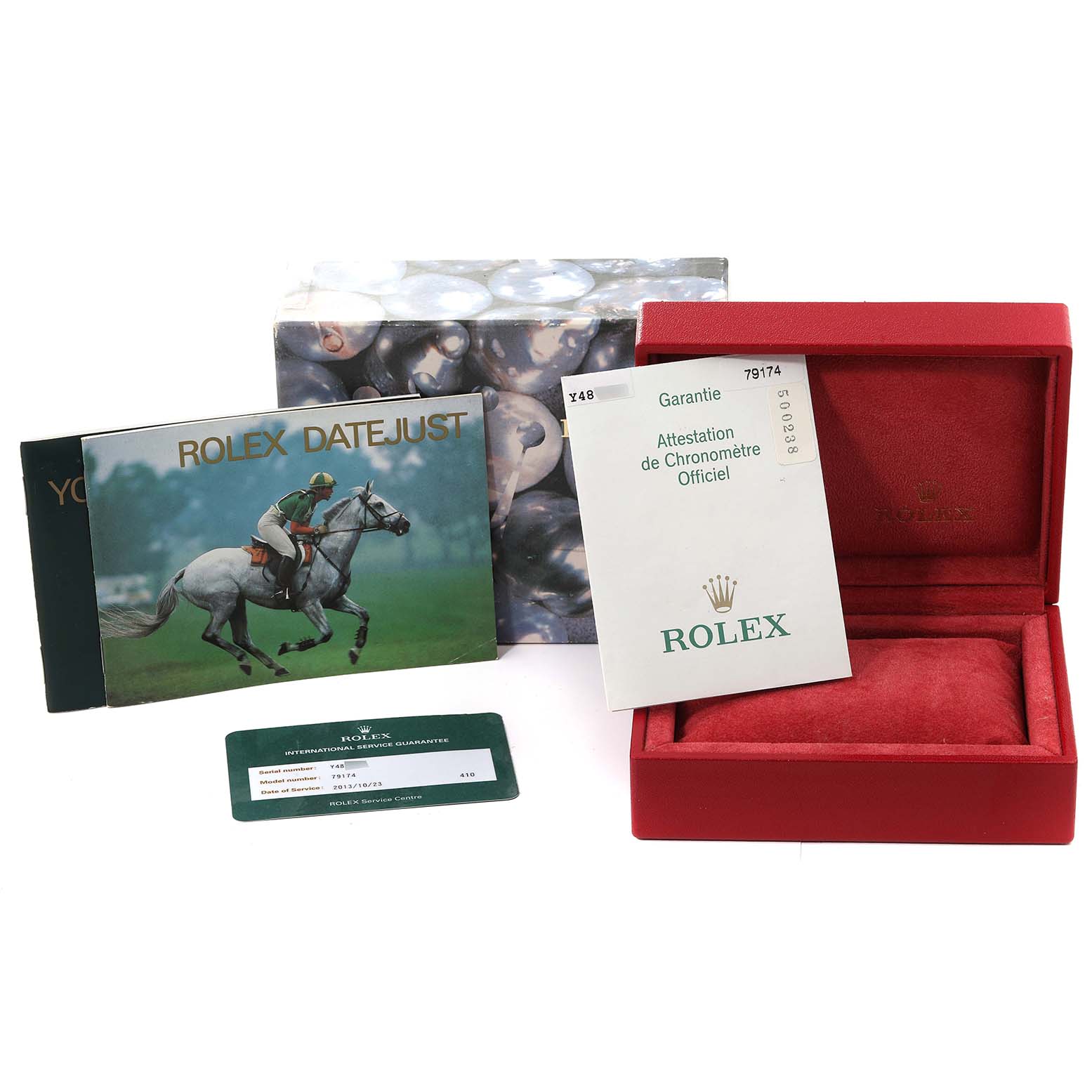 The image shows accessories for the Rolex Datejust 79174 Women's Stainless Steel White Dial 79174 Women's Stainless Steel White Dial, including a box, warranty card, manuals, and a certificate.
