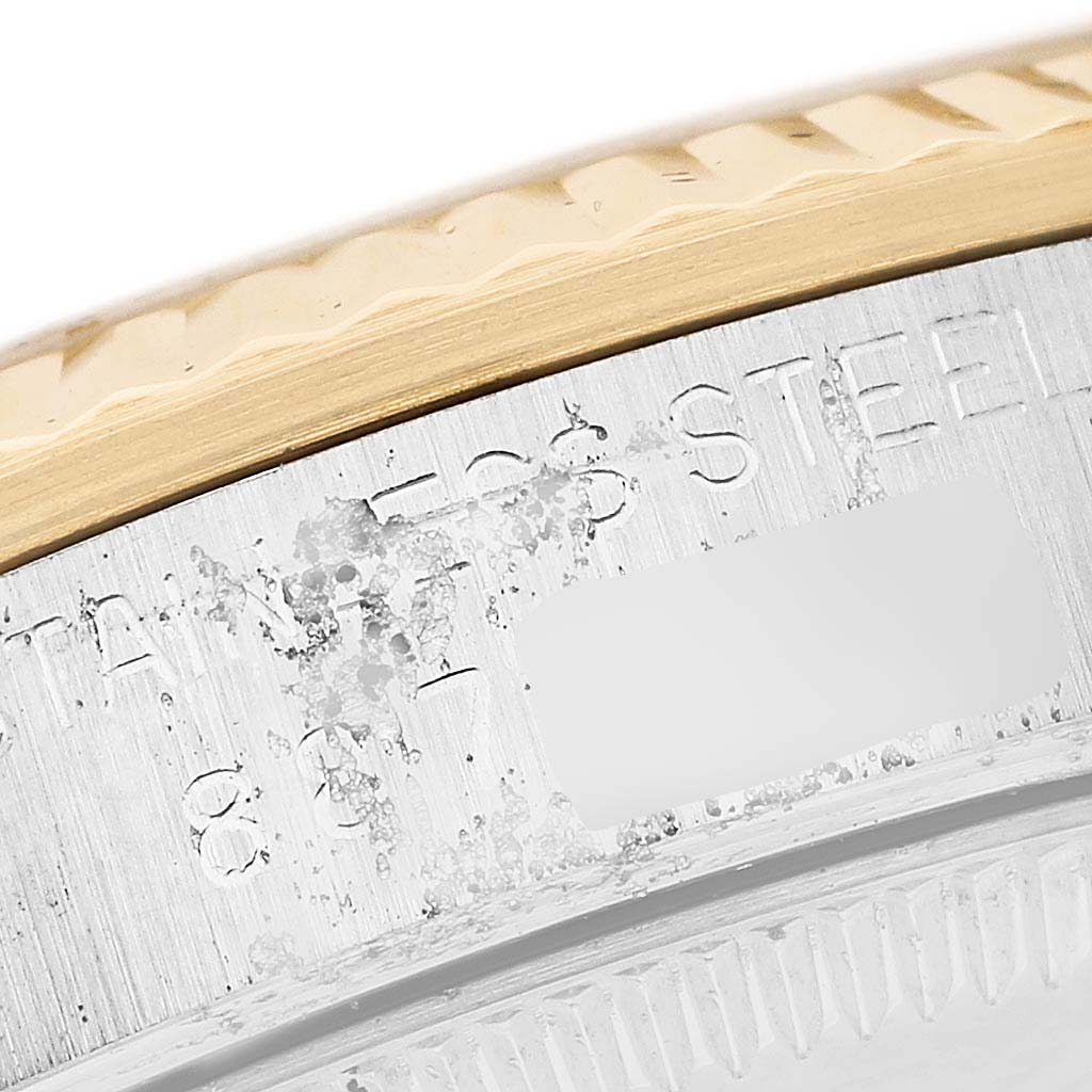The image shows a close-up of the case edge and bezel of a Rolex Mid-Size 68273 Women's Steel and Gold (two tone) Champagne Dial watch, highlighting the materials and engraved text.