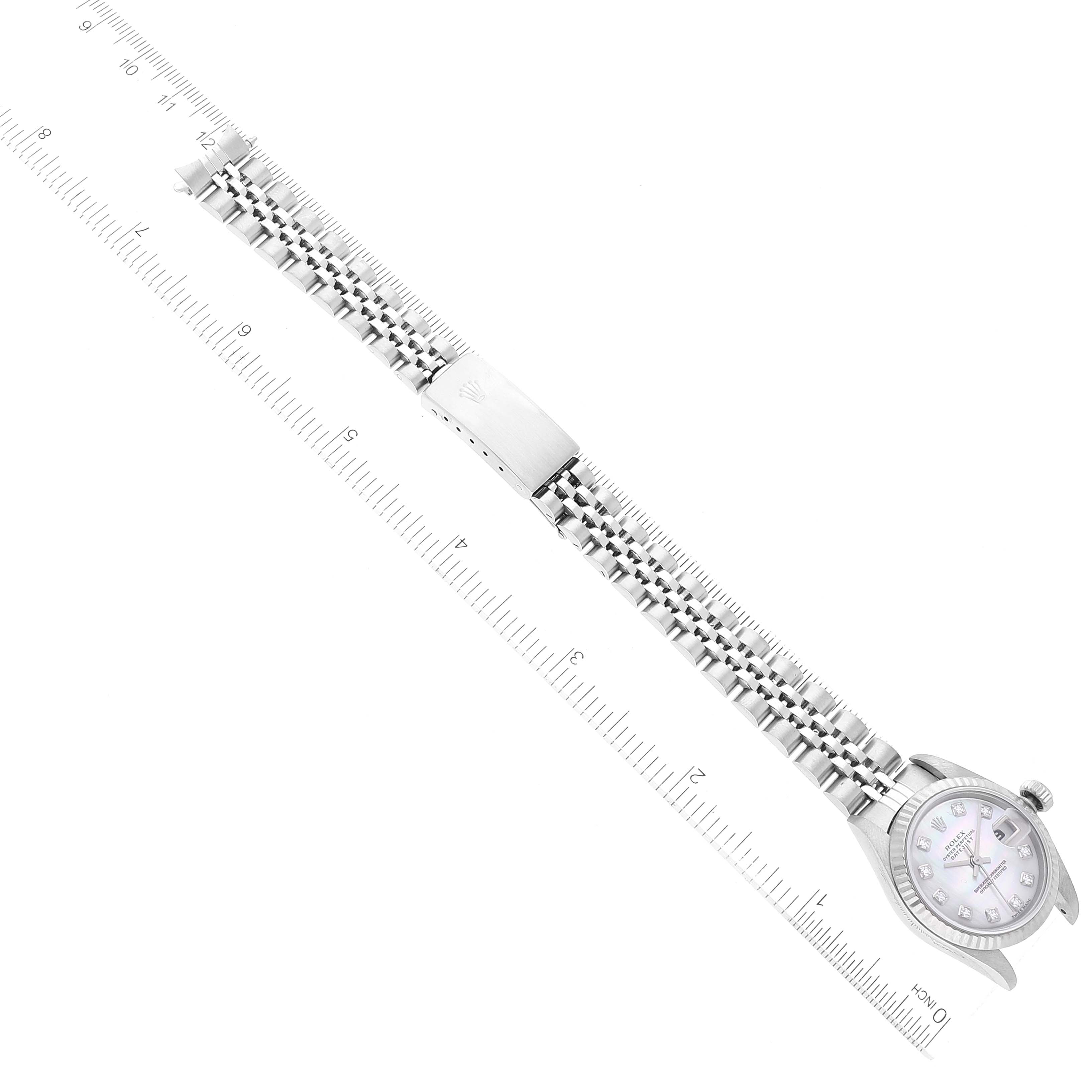 The image shows a top-down view of a Rolex Datejust 79174 Women's Stainless Steel Mother of Pearl Dial 79174 Women's Stainless Steel Mother of Pearl Dial watch, displaying its case, dial, and bracelet laid next to a ruler for scale.