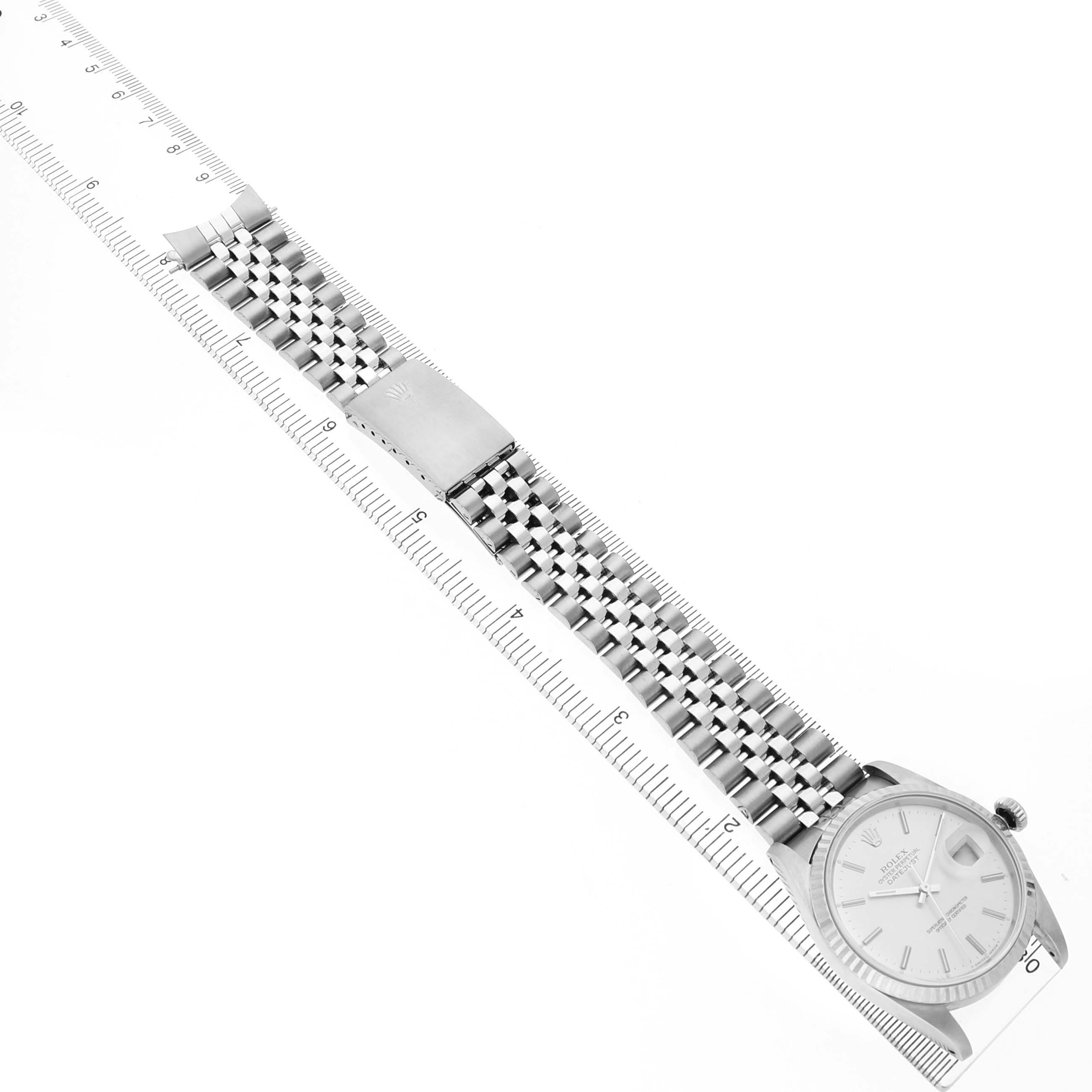 The Rolex Datejust 16234 Men's Stainless Steel Silver Dial watch is shown lengthwise with its bracelet fully extended, next to a ruler for scale.