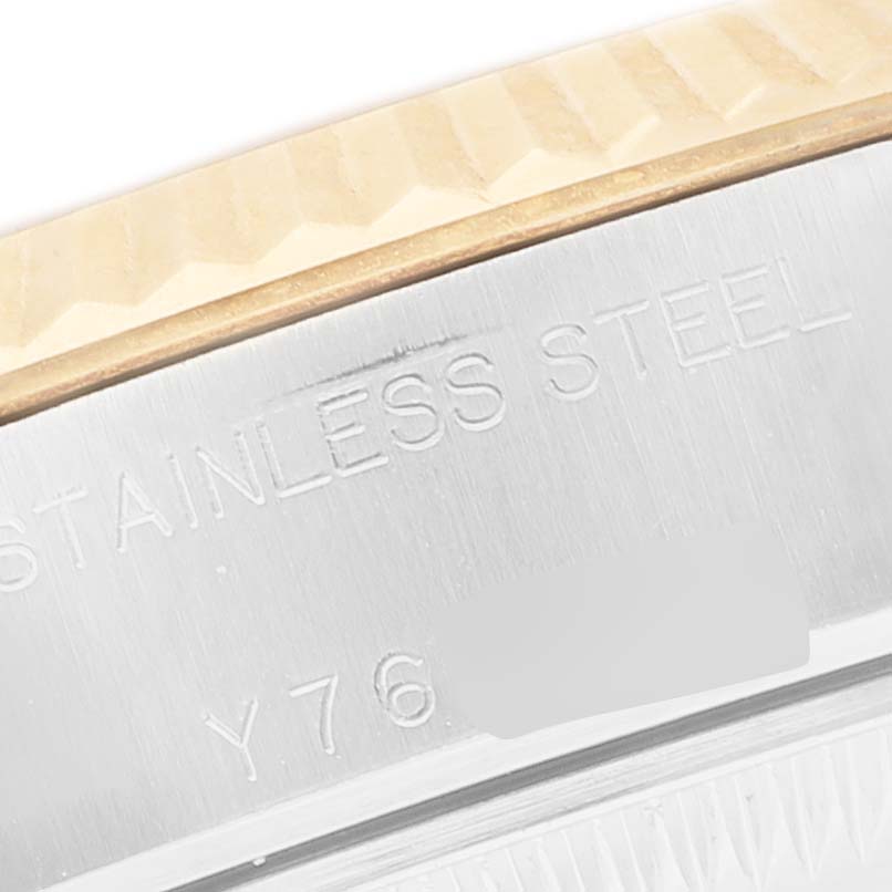 This close-up image of a Rolex Datejust 79173 Women's Steel and Gold (two tone) Champagne Dial shows the edge of the bezel and stainless steel casing with partial engravings.