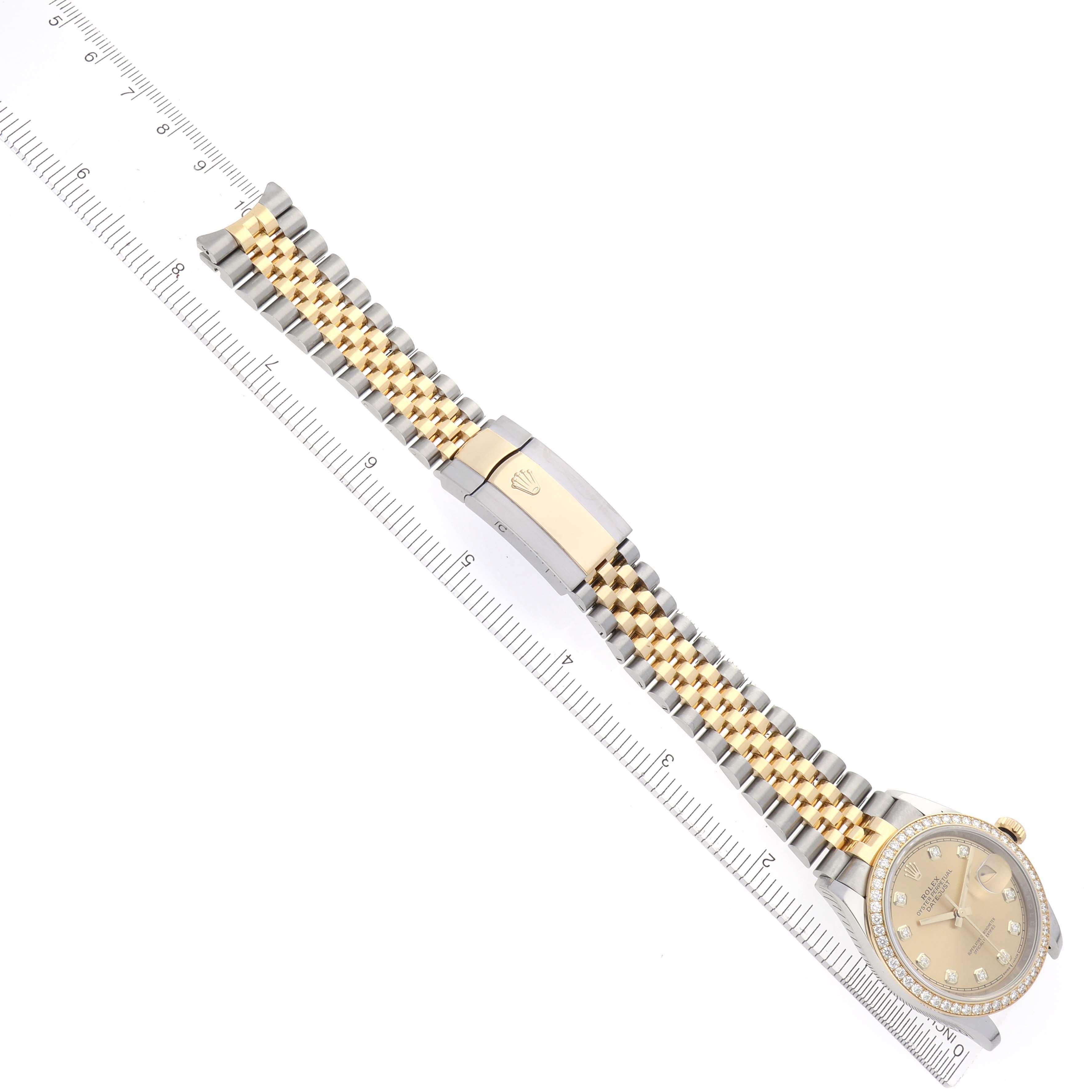 The image shows a Rolex Datejust 126283 Men's Steel and Gold (two tone) Champagne Dial 126283 Men's Steel and Gold (two tone) Champagne Dial watch from a top angle, highlighting its face, bracelet, and clasp alongside a ruler for scale.