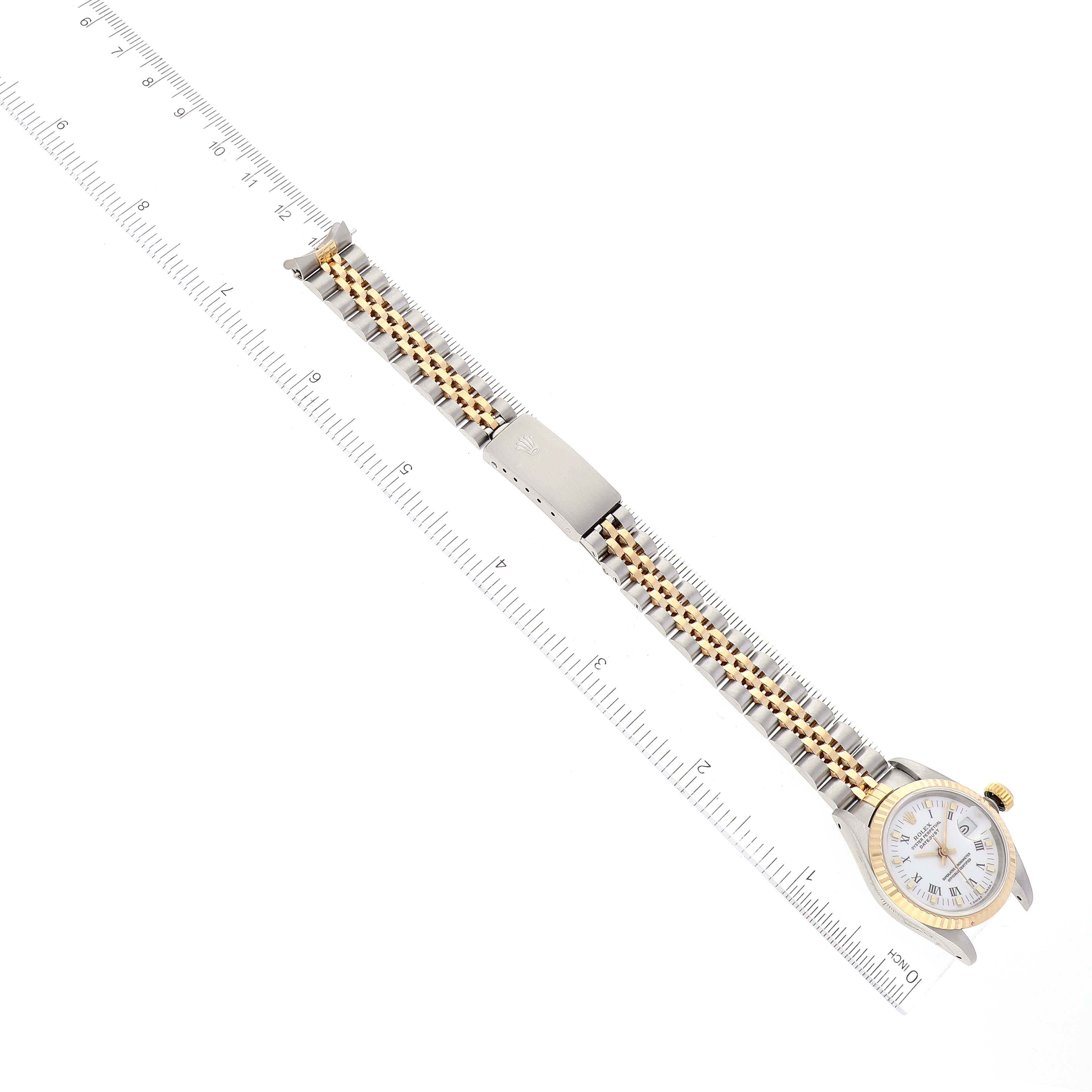 The image shows a Datejust Rolex watch displayed flat with its entire band extended and aligned with a ruler.