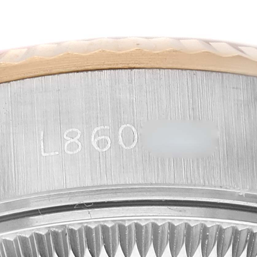 The image shows a close-up of the serial number engraving and fluted bezel on a Rolex Datejust 69173 Women's Steel and Gold (two tone) White Dial 69173 Women's Steel and Gold (two tone) White Dial watch.