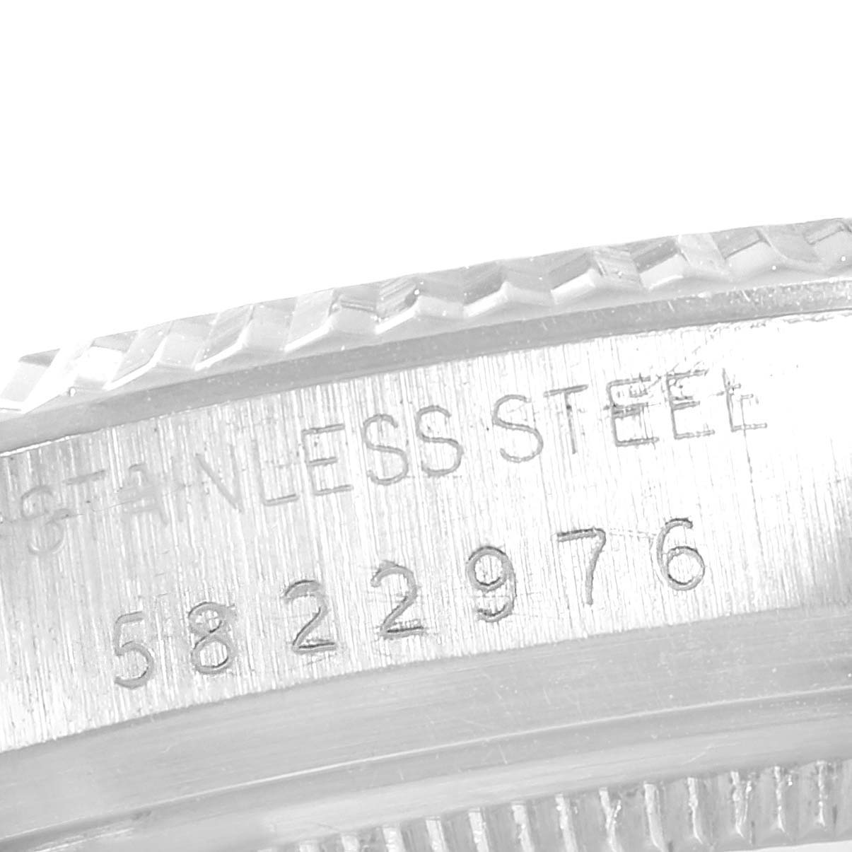 The image shows a close-up of the engraved serial number and "stainless steel" marking on the case of a Rolex Vintage Collection 16014 Men
s Stainless Steel Black Dial 16014 Men
s Stainless Steel Black Dial watch.