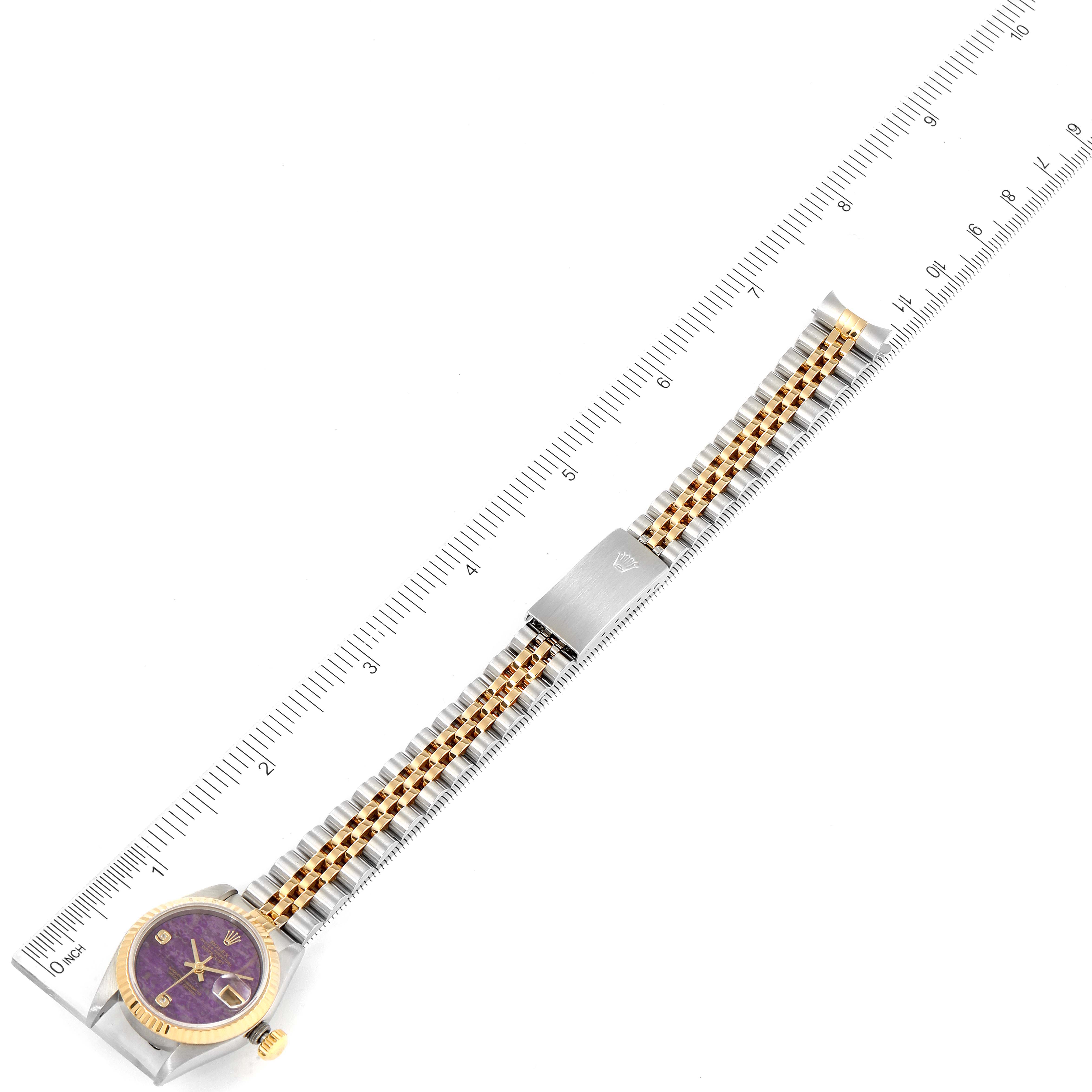 The image shows a Rolex Datejust 79173 Women's Steel and Gold (two tone) Purple Dial 79173 Women's Steel and Gold (two tone) Purple Dial watch laid flat against a ruler, displaying the full face, band, and clasp.
