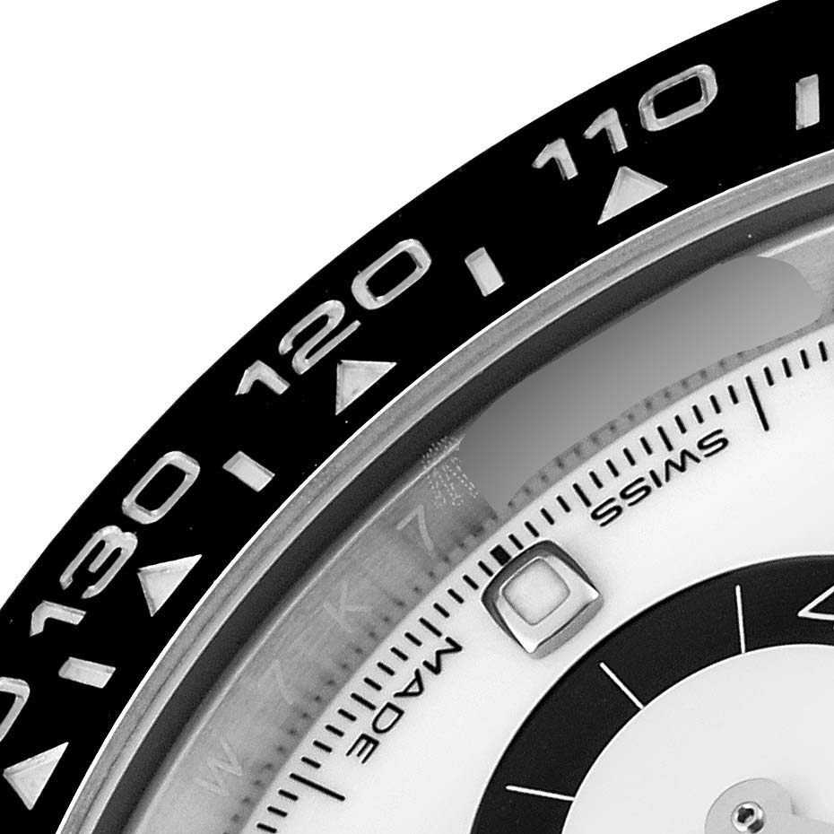 This image shows a close-up of the bezel and part of the dial of a Rolex Daytona 116500 Men's Stainless Steel White Dial 116500 Men's Stainless Steel White Dial watch.