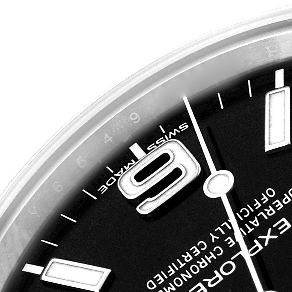 The image shows a close-up of the dial, specifically the "9" marker, part of the minute and hour hands, and some text on a Rolex Explorer 214270 Men
s Stainless Steel Black Dial 214270 Men
s Stainless Steel Black Dial watch.