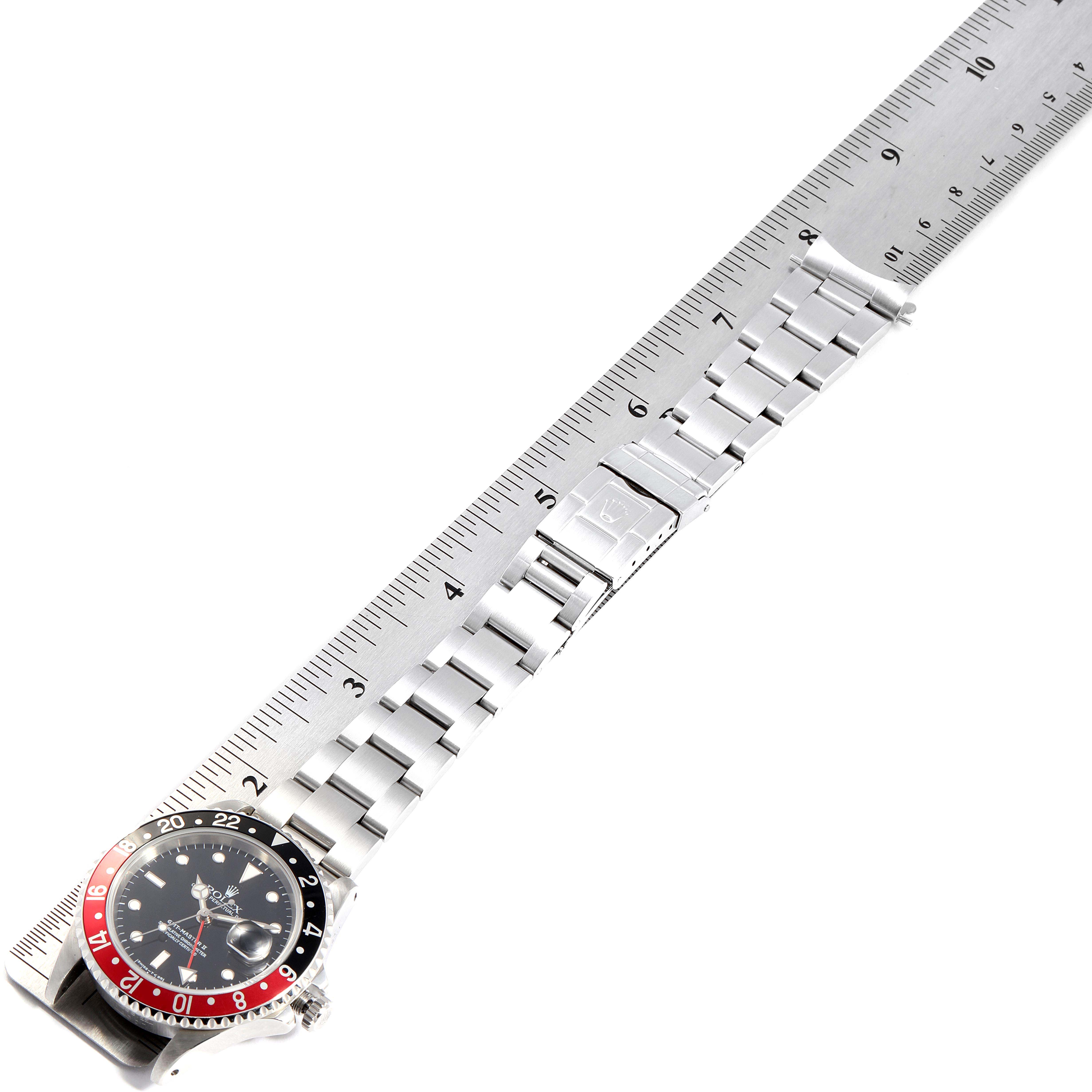 The Rolex GMT-Master 16710 Men's Stainless Steel Black Dial 16710 Men's Stainless Steel Black Dial watch is shown flat with its face, bracelet, and clasp visible, placed alongside a ruler.