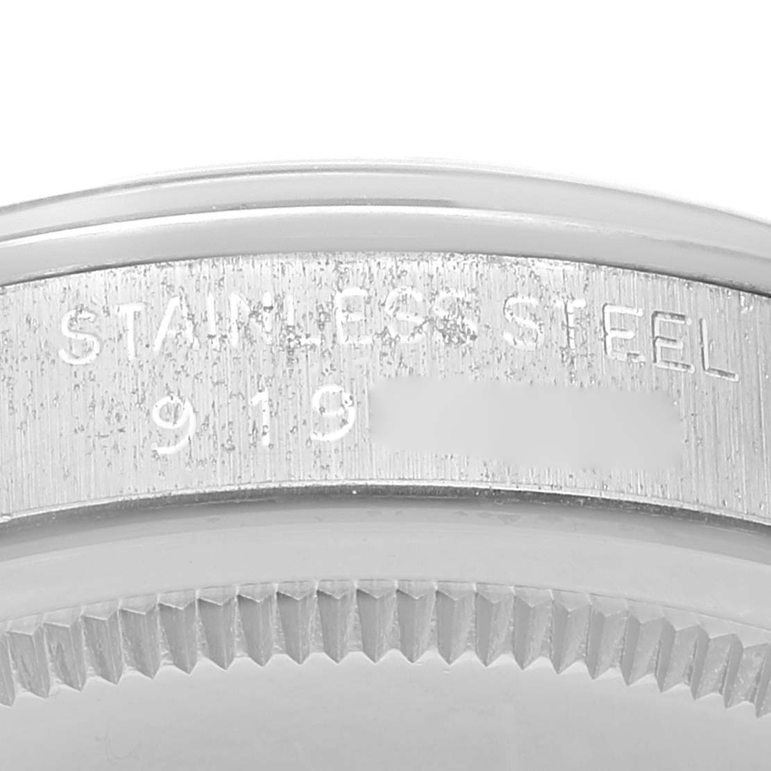 The image shows a close-up of the textured bezel and "stainless steel" engraving on a Vintage Collection Rolex watch.