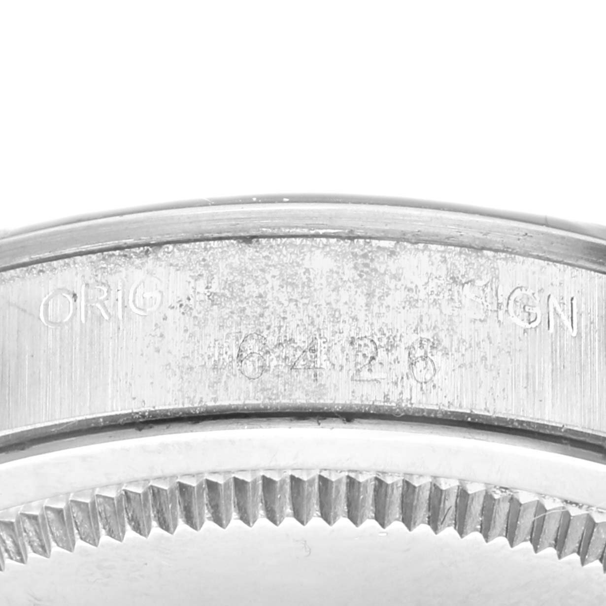 The image shows a close-up of the case side and the bezel of a Vintage Collection model by Rolex, highlighting the engraved serial number.