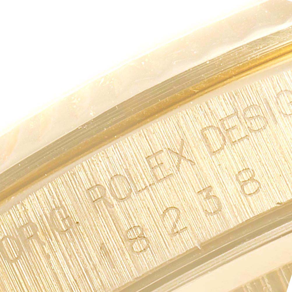 The image shows a close-up of the engraved bezel area of the Rolex President 18238 Men
s Yellow Gold White Dial 18238 Men
s Yellow Gold White Dial model watch.