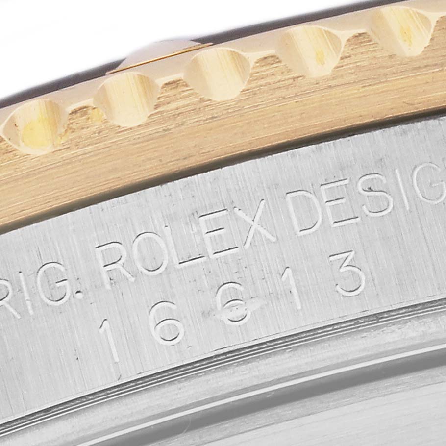 Close-up of the bezel and case side of a Rolex Submariner 16613 Men's Steel and Gold (two tone) Blue Dial 16613 Men's Steel and Gold (two tone) Blue Dial, showing the model's engraved design details.
