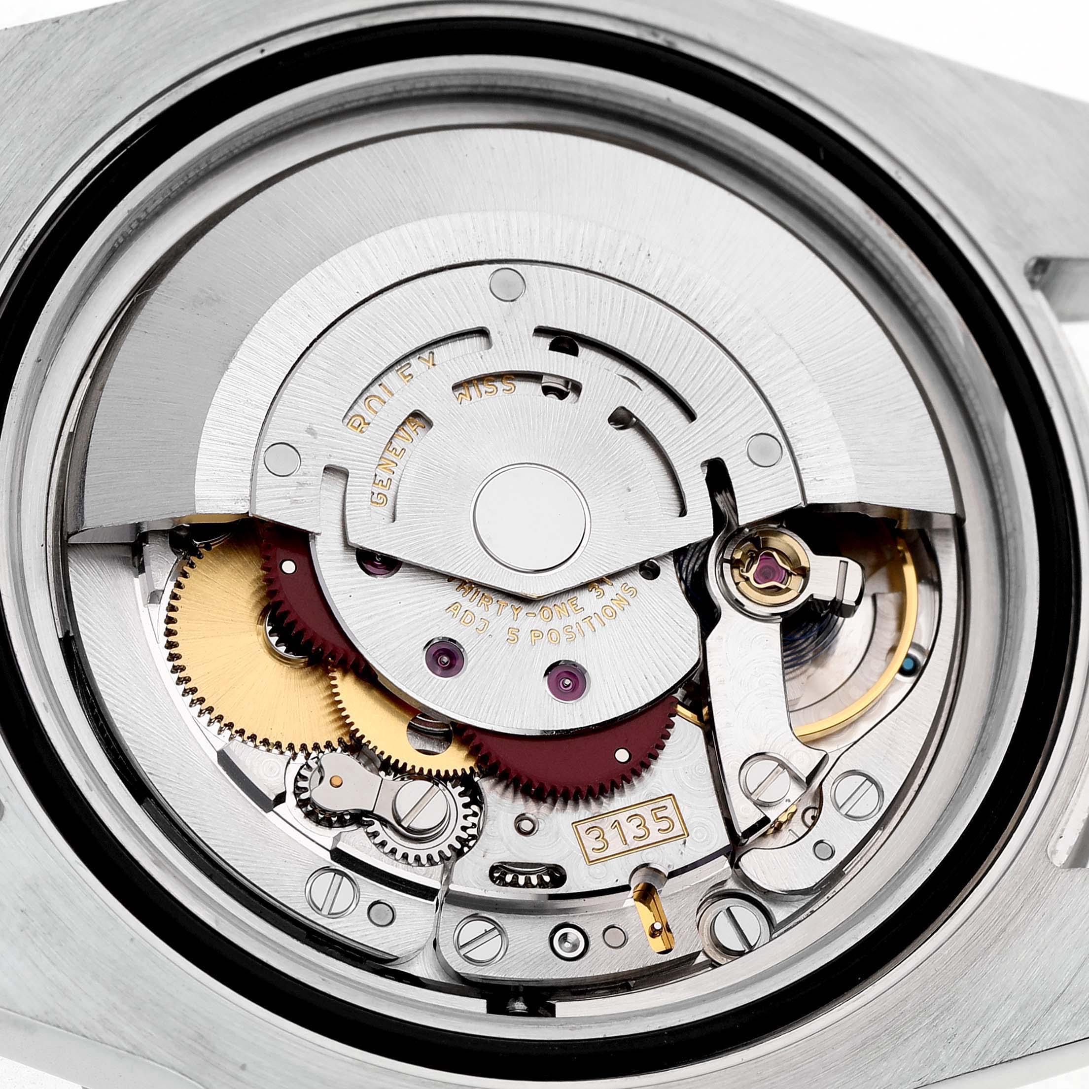 The image shows an angled view of the Rolex Sky-Dweller 116610 Men's Stainless Steel Black Dial's movement, highlighting gears, springs, and other internal mechanics.
