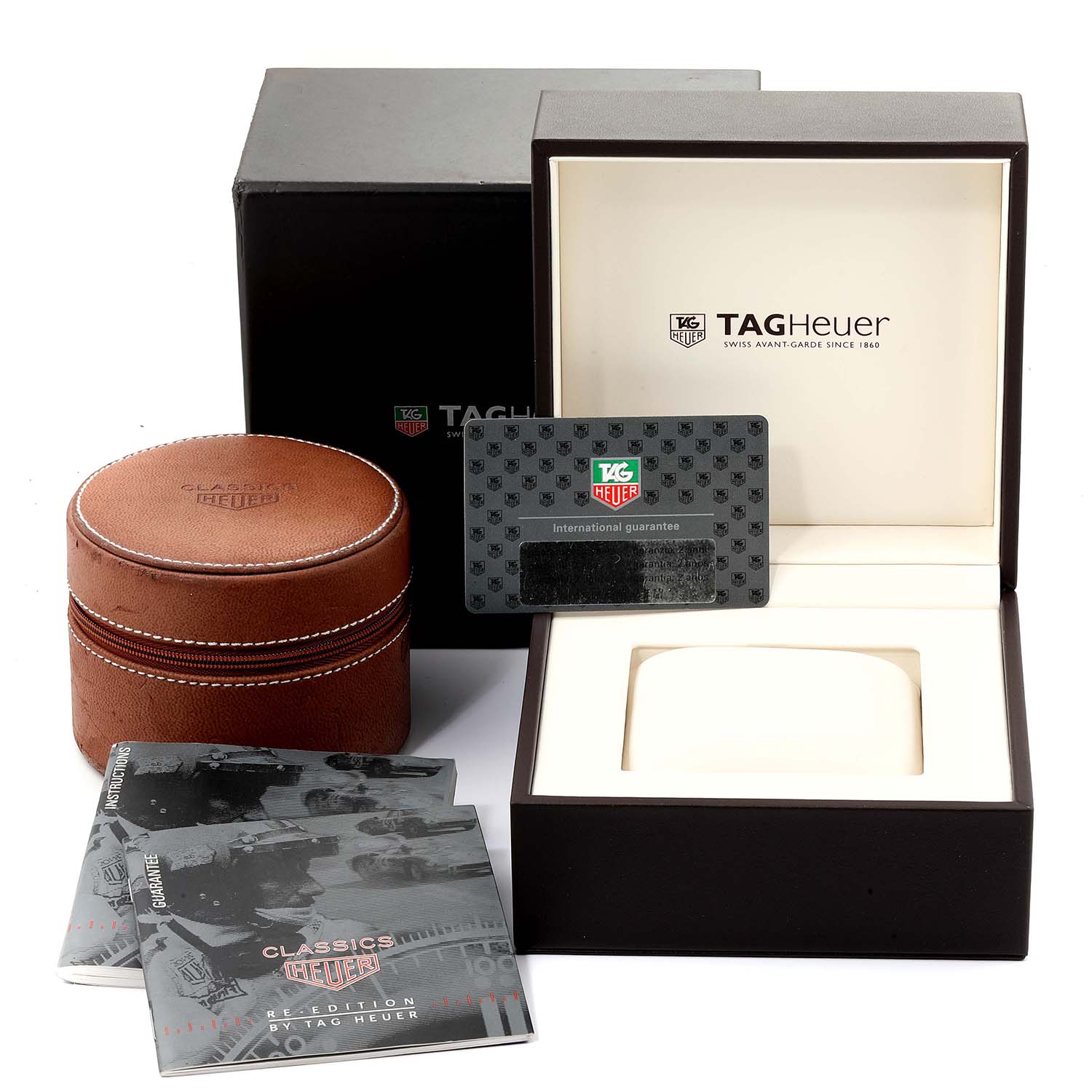 The image shows packaging accessories of a Tag Heuer Carrera CS3111 Men
s Stainless Steel Black Dial CS3111 Men
s Stainless Steel Black Dial watch, including the box, warranty card, manuals, and a brown leather case.