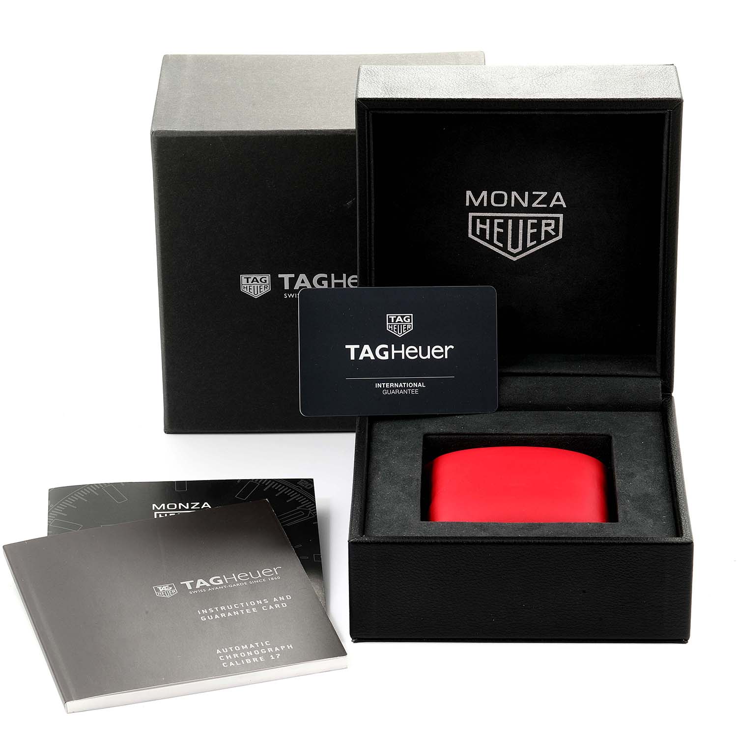 The image shows the Monza model by Tag Heuer's box, instruction manual, guarantee card, and red watch cushion.