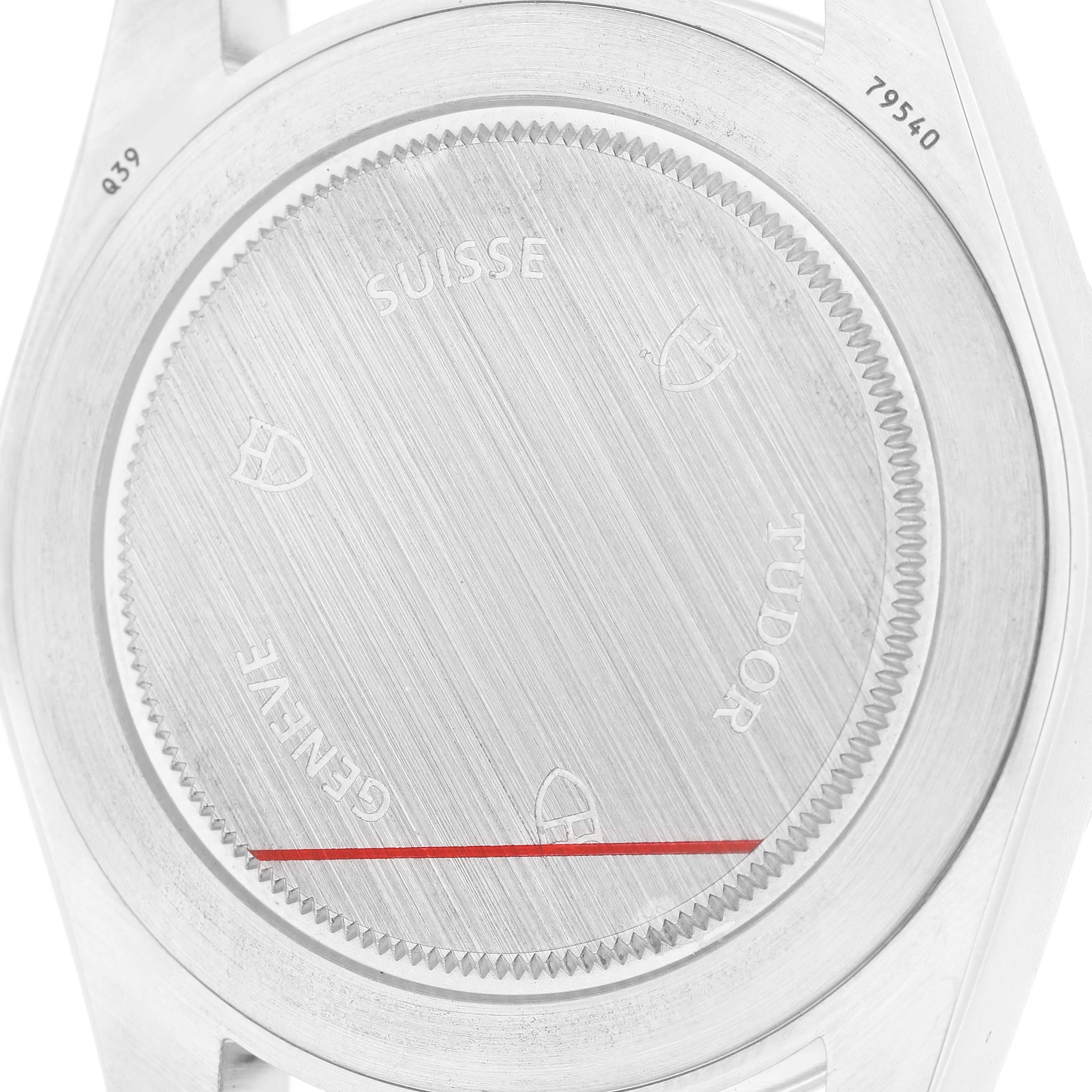 The image shows the back case of a Tudor Heritage Black Bay M79540 Men's Stainless Steel Silver Dial watch, featuring engravings and a brushed finish.