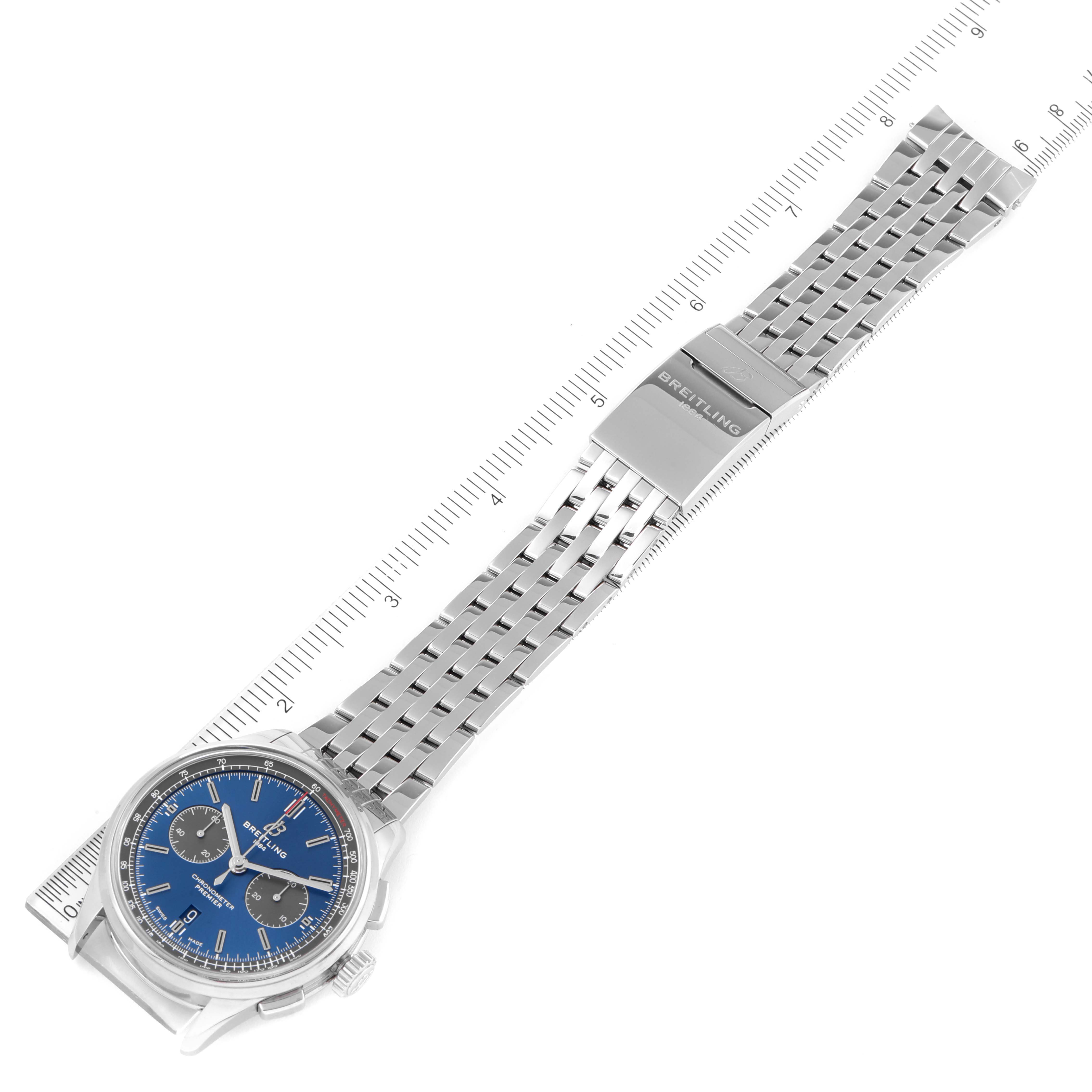 The image shows the Breitling Premier AB0118 Men's Stainless Steel Blue Dial AB0118 Men's Stainless Steel Blue Dial model watch from a top-down angle, including the face, case, and full metal bracelet alongside a ruler.
