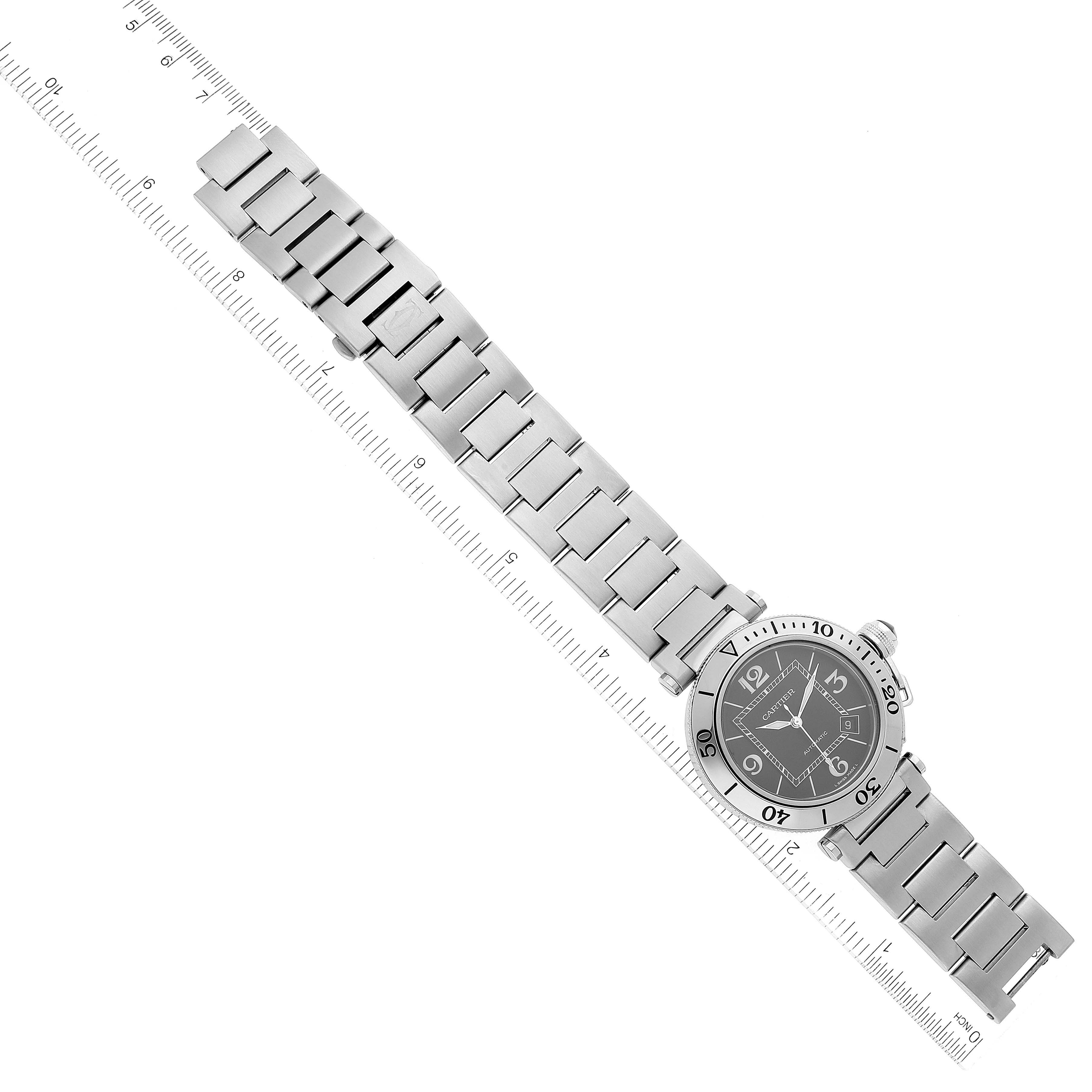 The image shows a top-down view of the Pasha model by Cartier, displaying the watch face and metal bracelet.