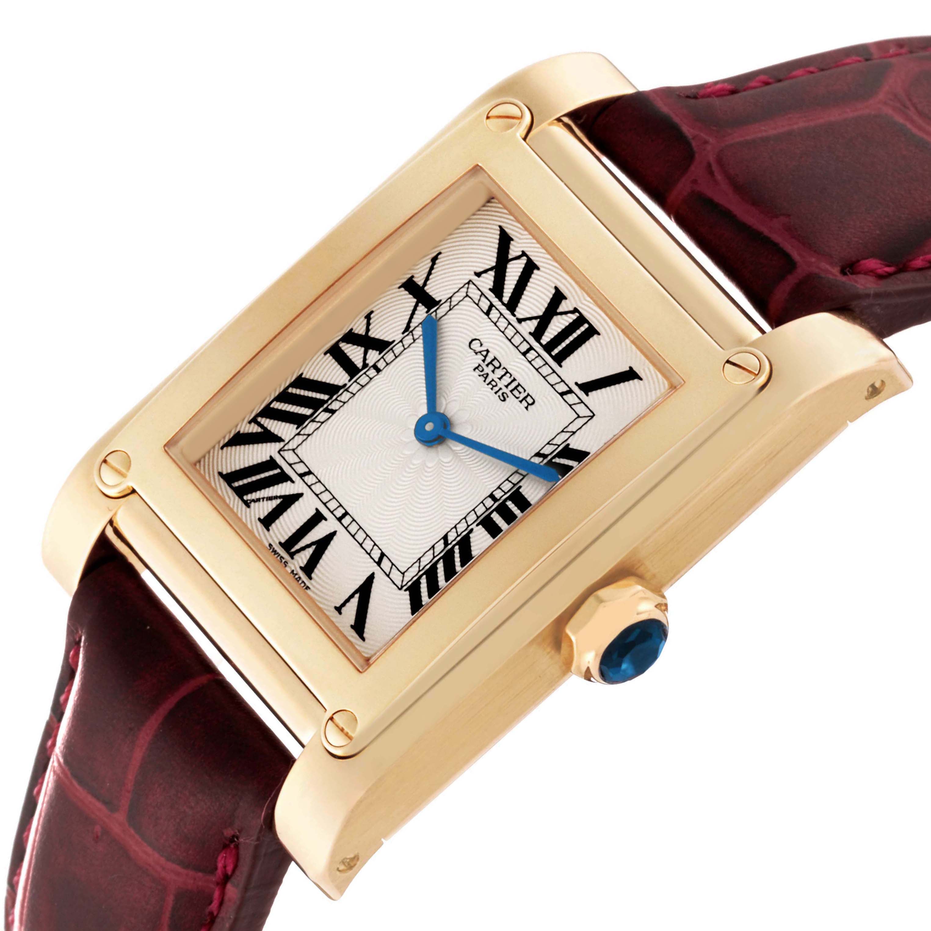 The Cartier Tank A Vis W1529451 Men's Yellow Gold Silver Dial W1529451 Men's Yellow Gold Silver Dial watch is angled to show the rectangular face, blue hands, Roman numerals, and side crown with a blue gem.