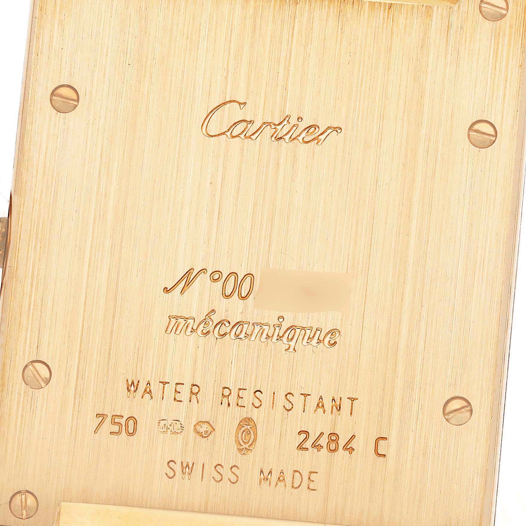 The image shows the back of a Cartier Tank A Vis W1529451 Men's Yellow Gold Silver Dial W1529451 Men's Yellow Gold Silver Dial watch, featuring engravings and screws.