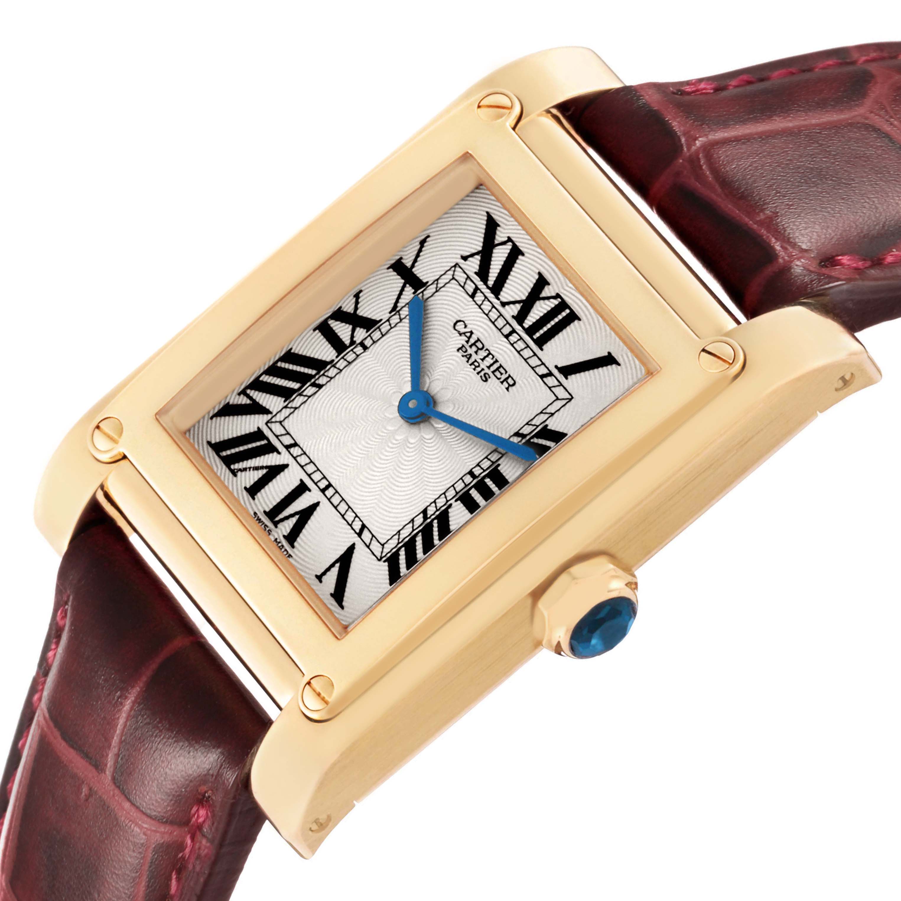 The Cartier Tank A Vis W1529451 Men's Yellow Gold Silver Dial watch is shown from a side angle, highlighting its gold casing, Roman numerals, and crown with a blue cabochon.