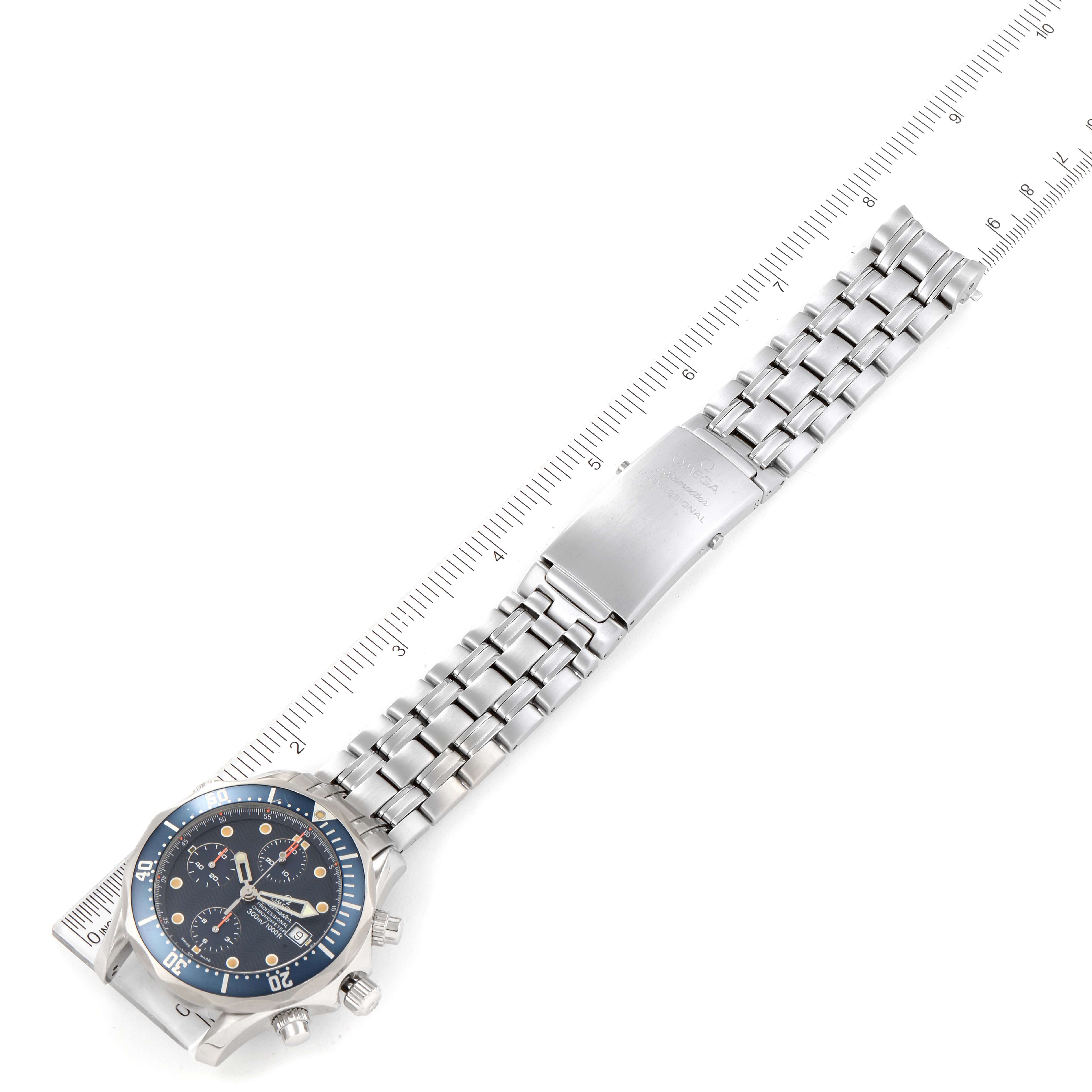 The image shows a top-down view of an Omega Seamaster 2225.80.00 Men's Stainless Steel Blue Dial 2225.80.00 Men's Stainless Steel Blue Dial watch, highlighting the face, band, and clasp next to a ruler for scale.