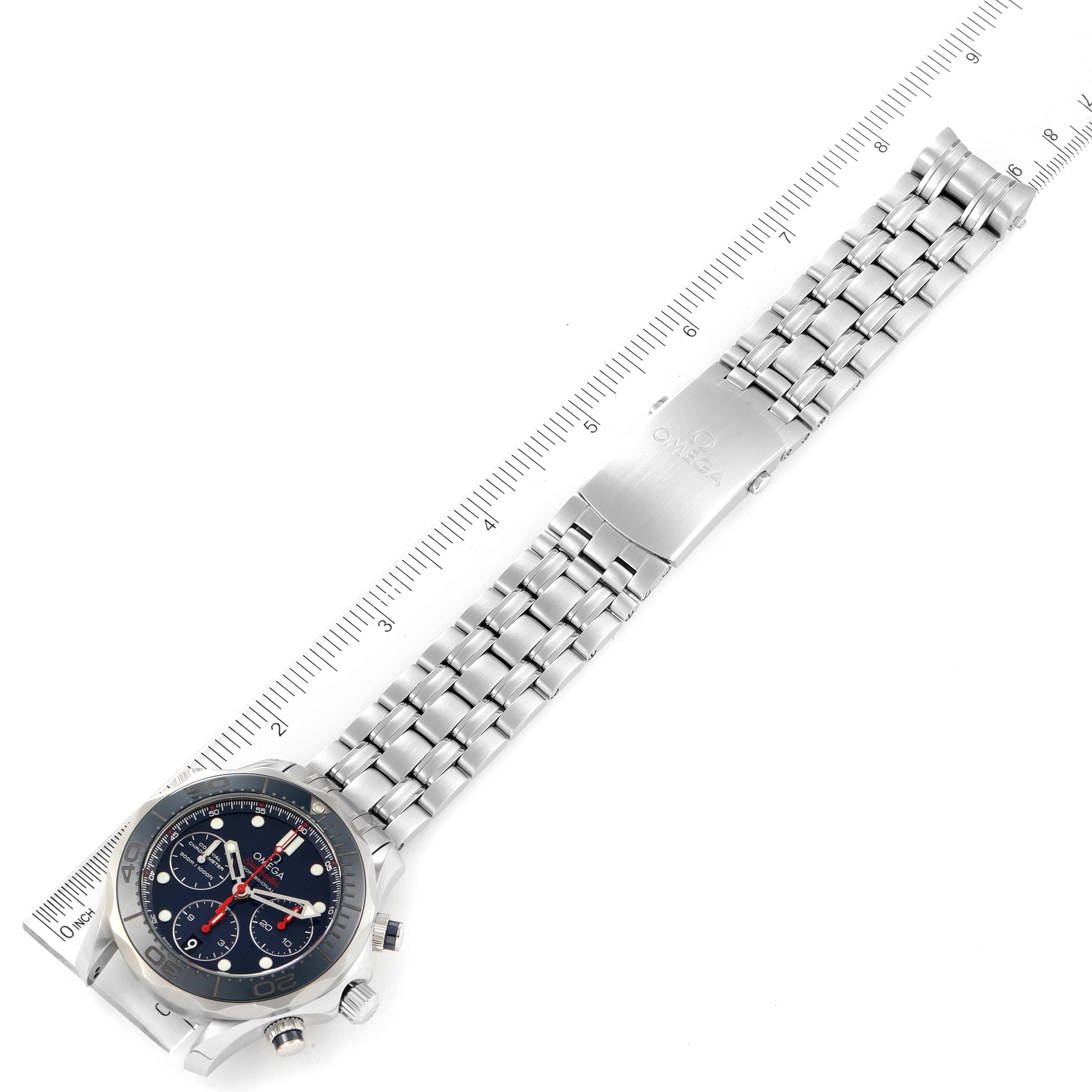 The Omega Seamaster 212.30.42.50.03.001 Men
s Stainless Steel Blue Dial 212.30.42.50.03.001 Men
s Stainless Steel Blue Dial watch is shown from an angled top view, displaying the face, band, and clasp next to a ruler.