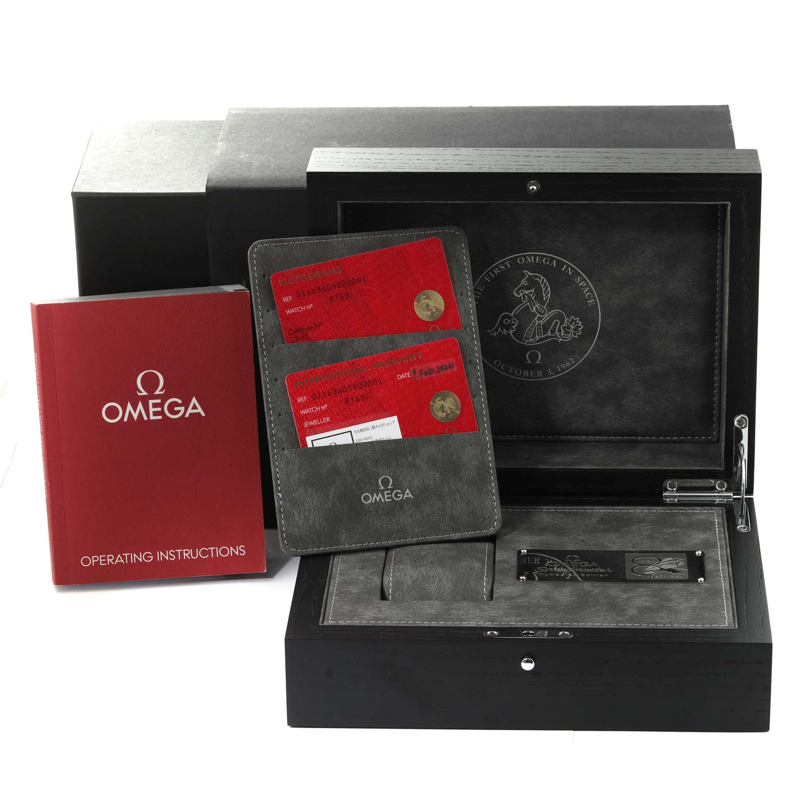 This image shows the box, operating instructions, and warranty cards for the Omega Speedmaster 311.63.40.30.02.001 Men's Rose Gold Silver Dial 311.63.40.30.02.001 Men's Rose Gold Silver Dial watch, viewed from the front.