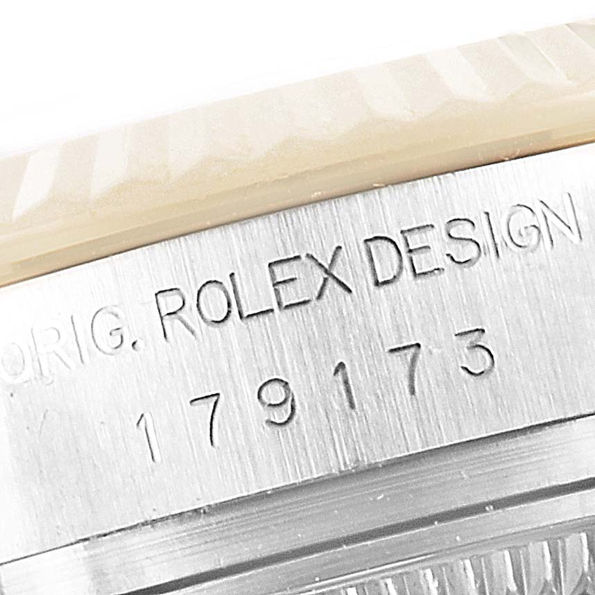 This close-up image shows the engraved model and serial number along with the design mark on the case of a Rolex Datejust 179173 Women's Steel and Gold (two tone) White Dial 179173 Women's Steel and Gold (two tone) White Dial watch.