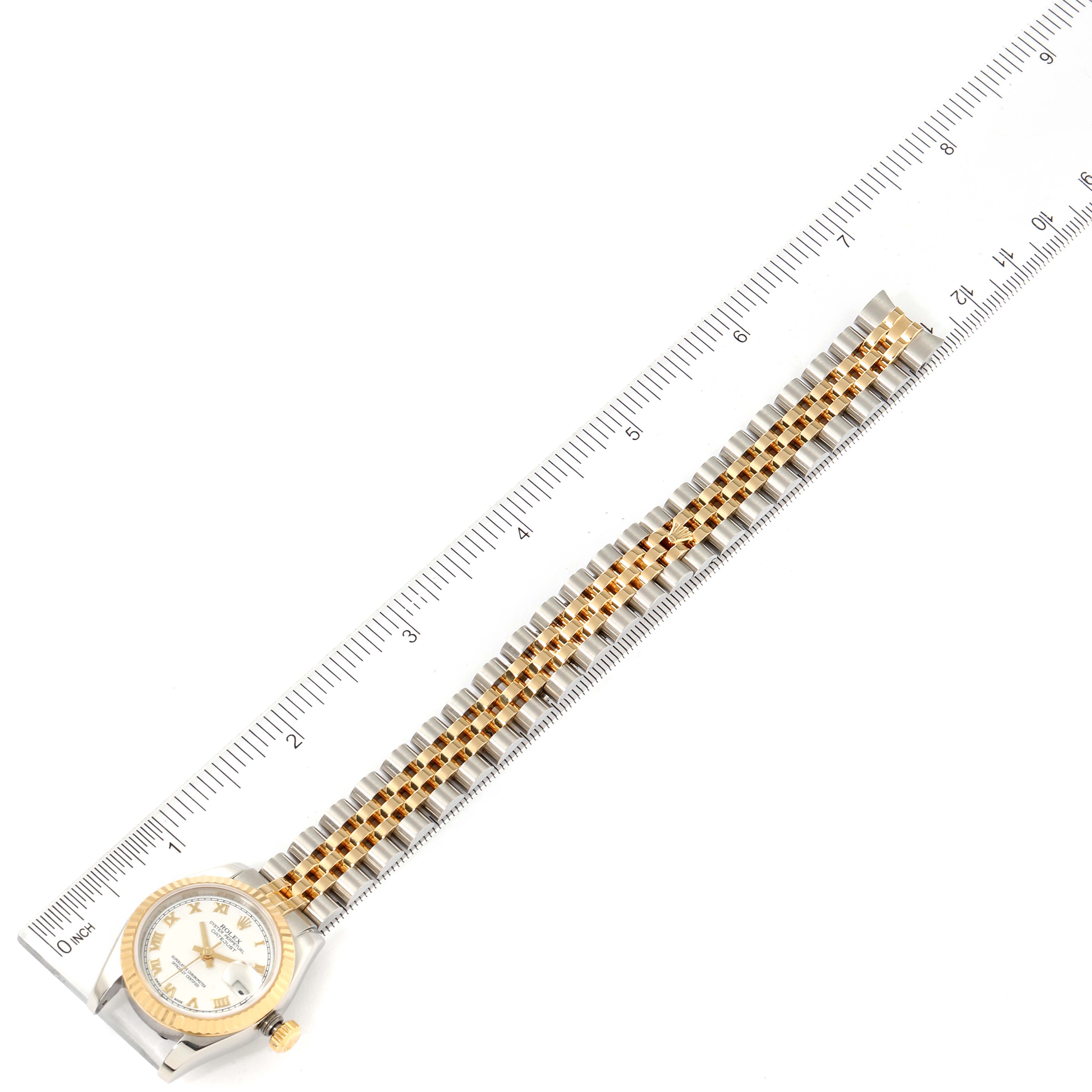 This image shows a top-down view of a Rolex Datejust 179173 Women's Steel and Gold (two tone) White Dial 179173 Women's Steel and Gold (two tone) White Dial watch, including the face, bezel, and full bracelet, alongside a ruler.