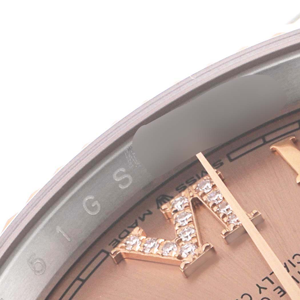 This close-up image of a Rolex Datejust 126231 Men's Steel and Gold (two tone) Pink Dial 126231 Men's Steel and Gold (two tone) Pink Dial watch shows part of the dial and a section of the bezel.
