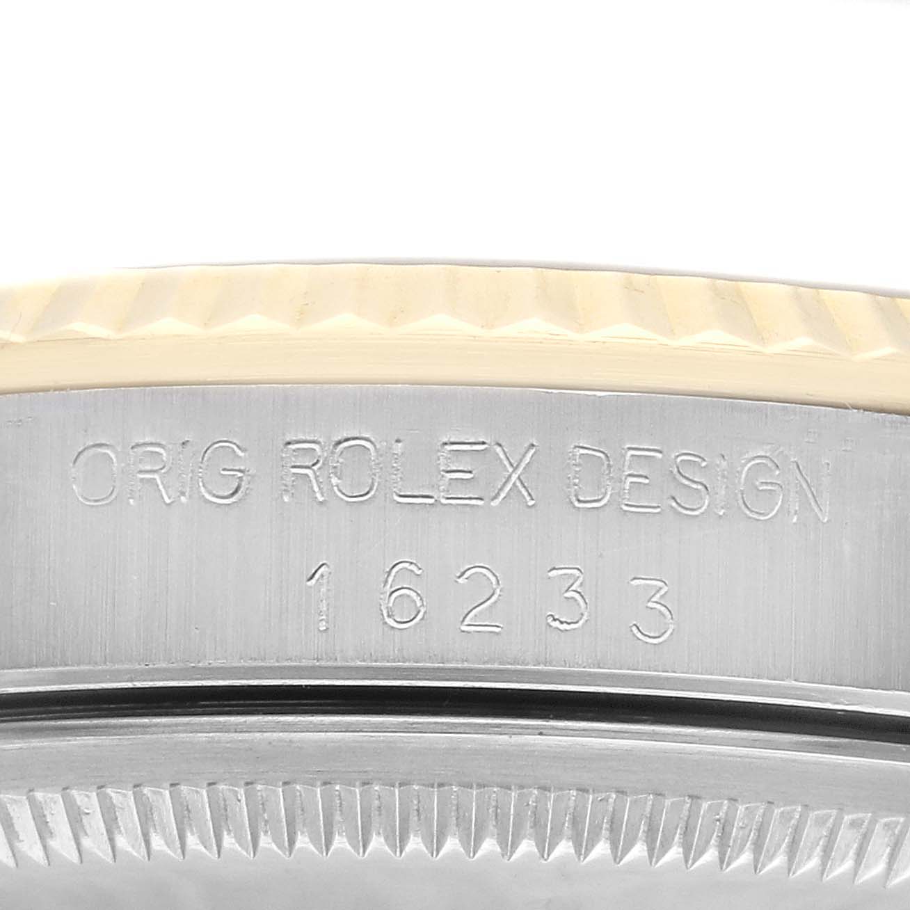 This close-up shot of a Rolex Datejust 16233 Men's Steel and Gold (two tone) Grey Dial 16233 Men's Steel and Gold (two tone) Grey Dial watch shows the case side with the serial number and engraving details.