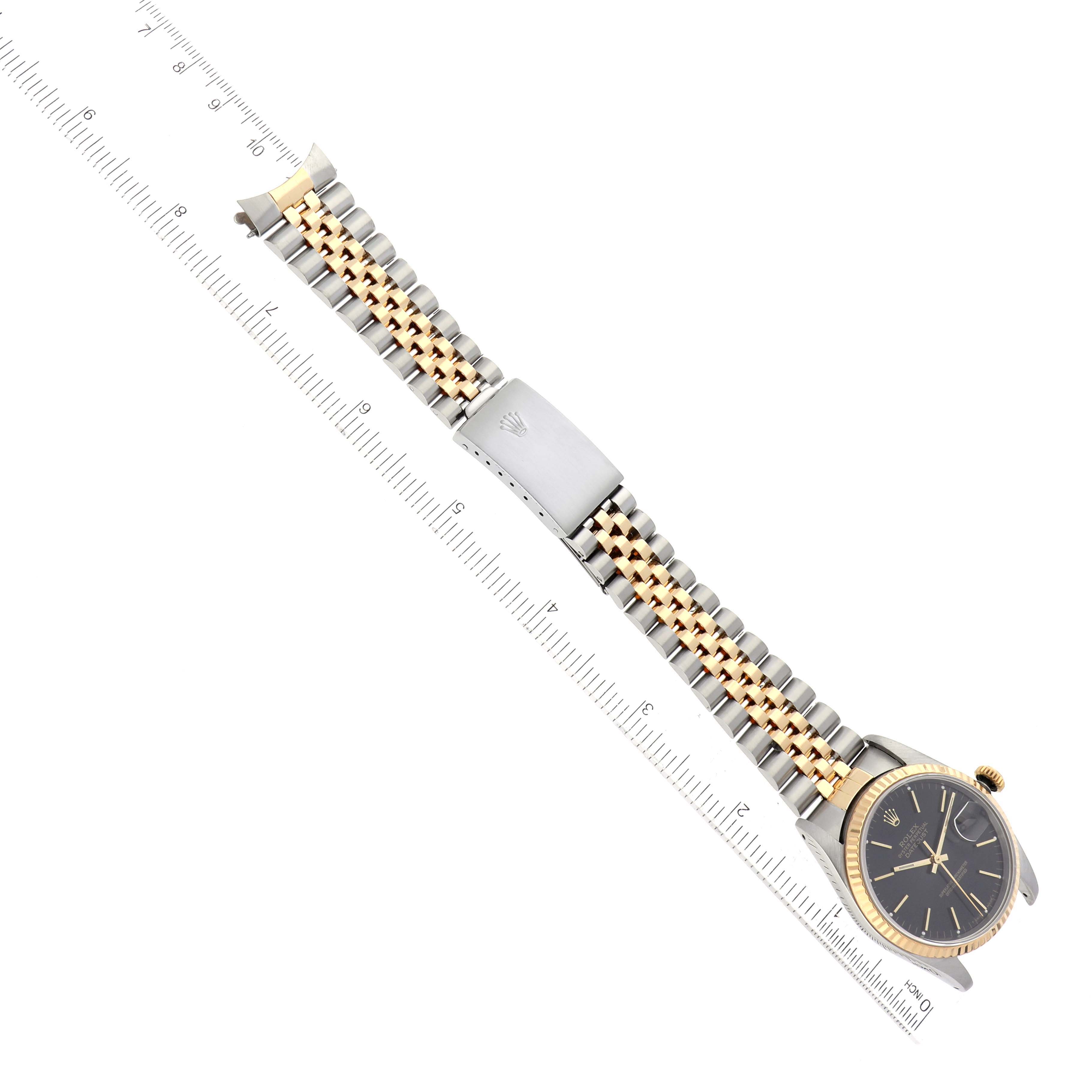 The image shows a Rolex Datejust 16233 Men's Steel and Gold (two tone) Grey Dial 16233 Men's Steel and Gold (two tone) Grey Dial watch laid flat, highlighting its face, bracelet, and clasp, alongside a ruler for measurement.