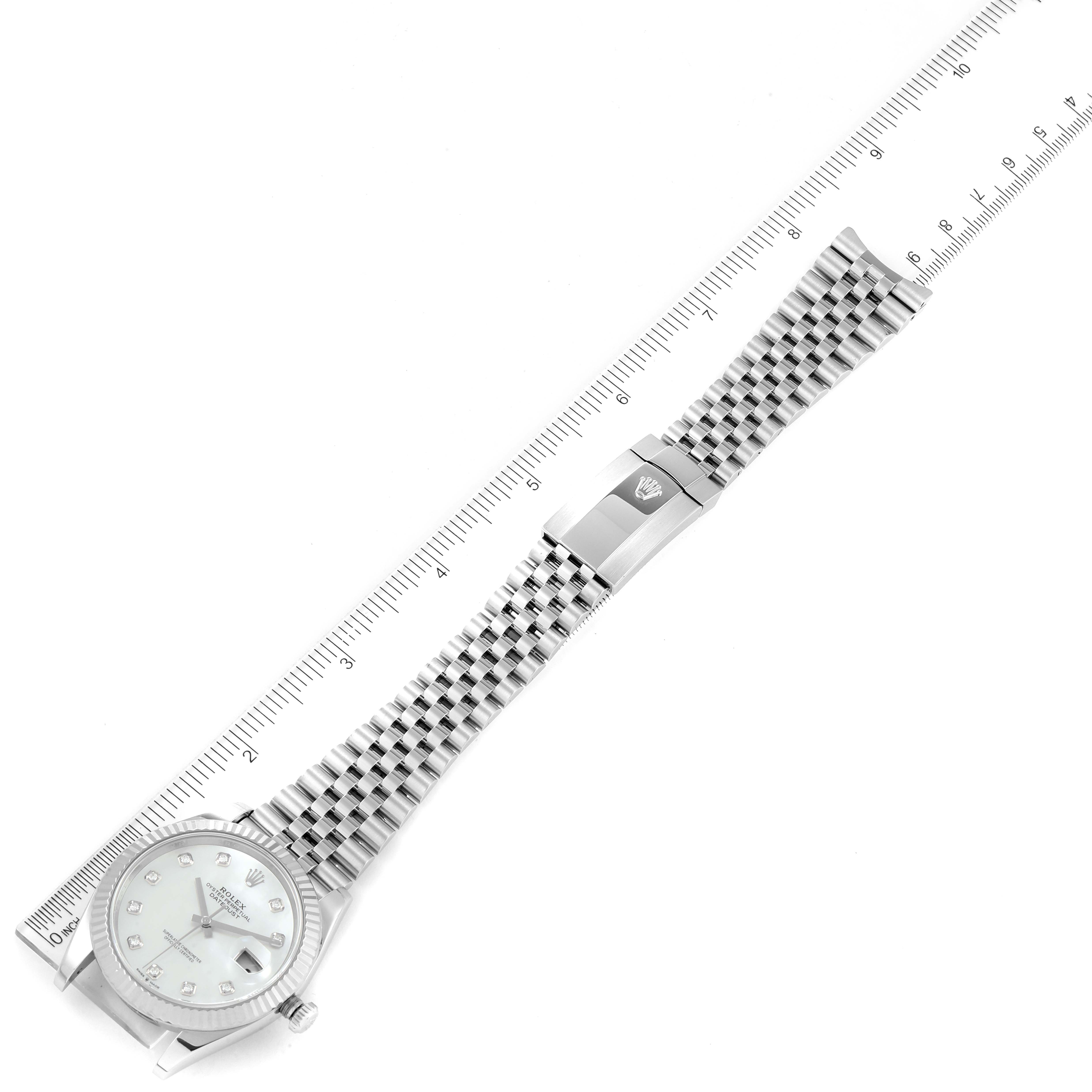 The photo shows a Rolex Datejust 41 126334 Men's Stainless Steel Mother of Pearl Dial 126334 Men's Stainless Steel Mother of Pearl Dial watch from an angled top-down view, highlighting the bracelet and part of the dial with a ruler beside it.