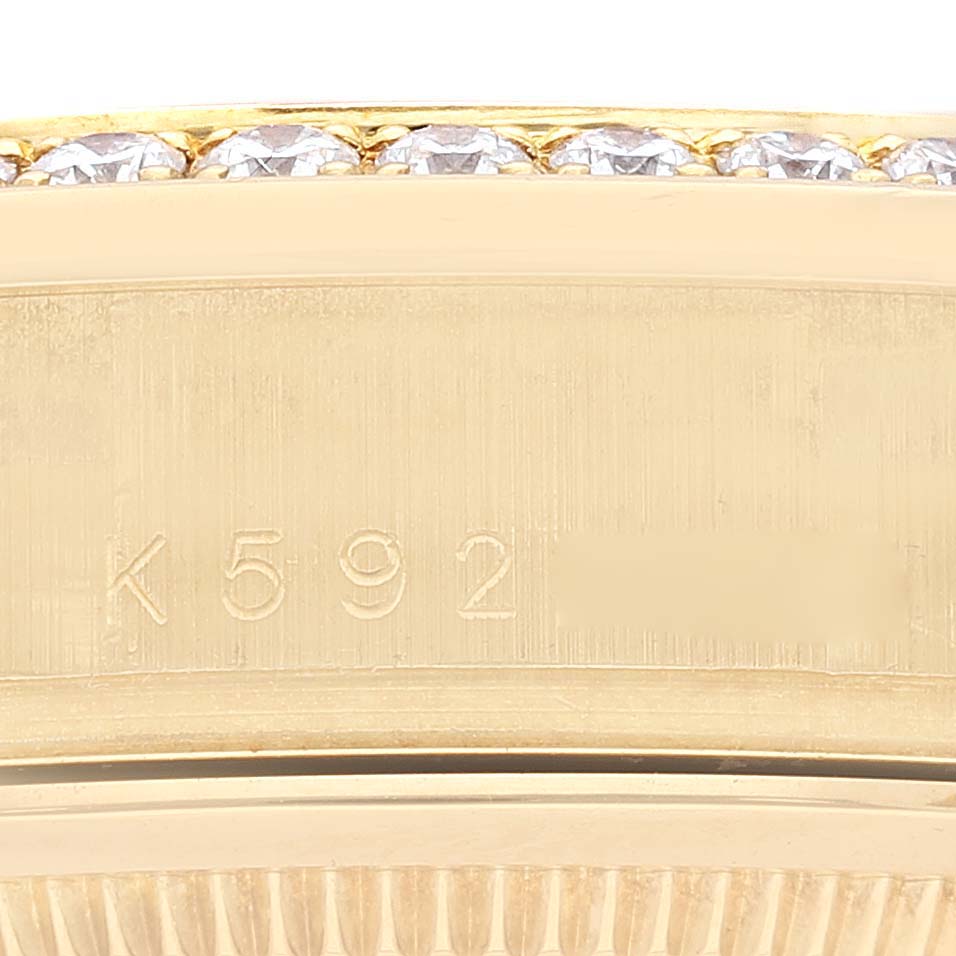 This close-up image of a Rolex President 118388 Men's Yellow Gold Champagne Dial 118388 Men's Yellow Gold Champagne Dial model shows the side engraving and part of the diamond-studded bezel.