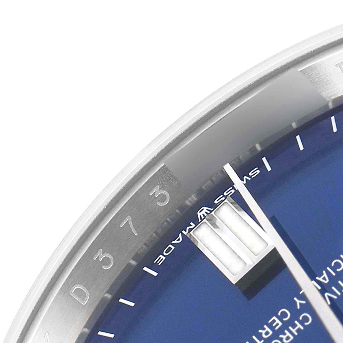 The image shows a close-up of the dial and part of the bezel of a Rolex Oyster Perpetual 126000 Men's Stainless Steel Blue Dial 126000 Men's Stainless Steel Blue Dial watch.