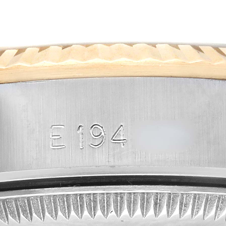 The image shows a close-up angle of the Oyster Perpetual Rolex watch's engraved case and fluted bezel.