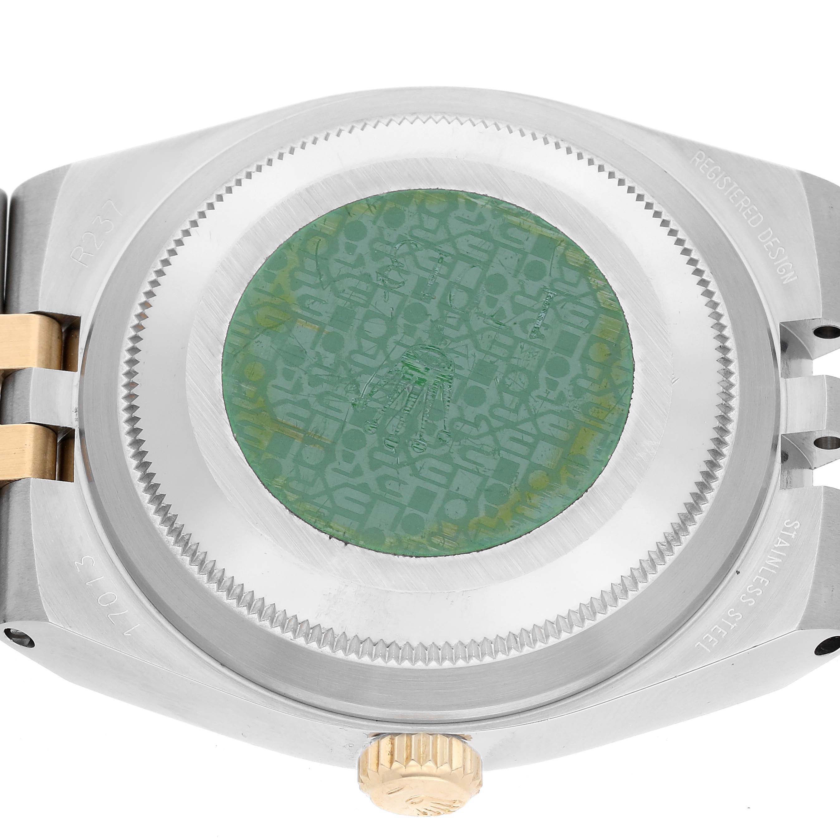 The image shows the case back of a Rolex Oysterquartz 17013 Men
s Steel and Gold (two tone) Champagne Dial 17013 Men
s Steel and Gold (two tone) Champagne Dial watch with its green sticker and part of the two-tone bracelet.